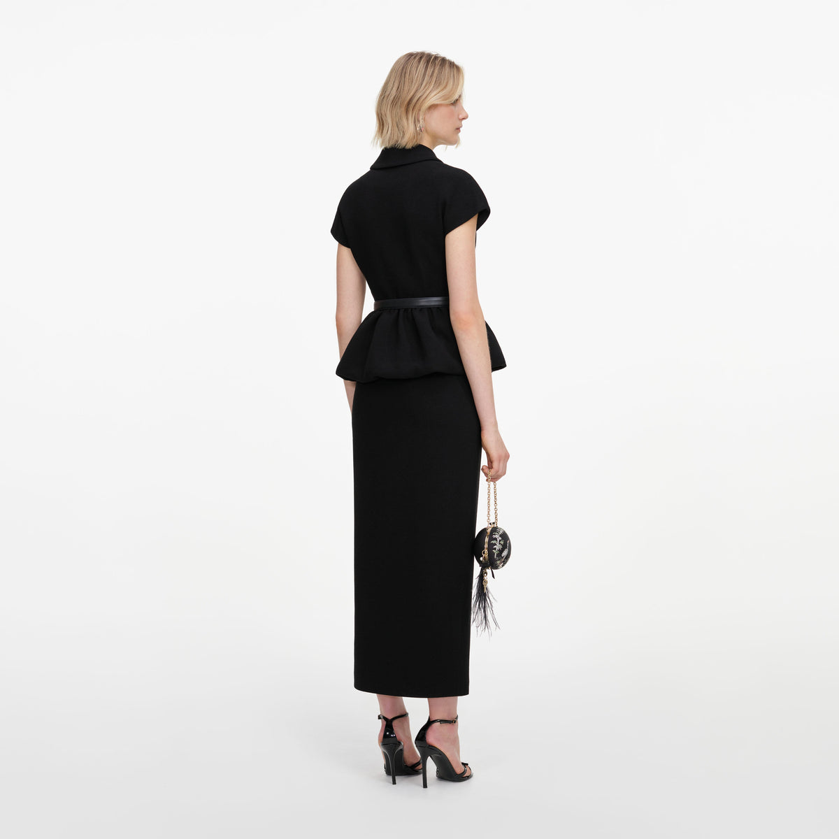 Back view of a woman wearing the Black Crepe Peplum Midi Dress