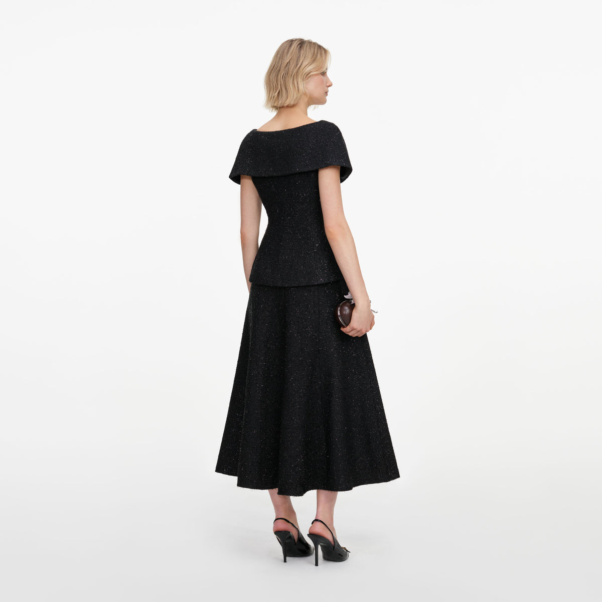 Back view of a woman wearing the Black Tinsel Boucle Brooch Midi Dress