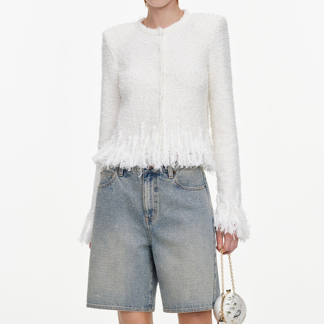A close up of a woman wearing the White Fringe Knit Cardigan