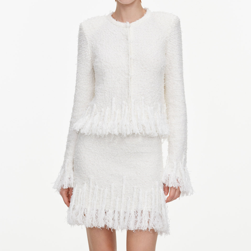 A close up of a woman wearing the White Fringe Knit Mini Skirt