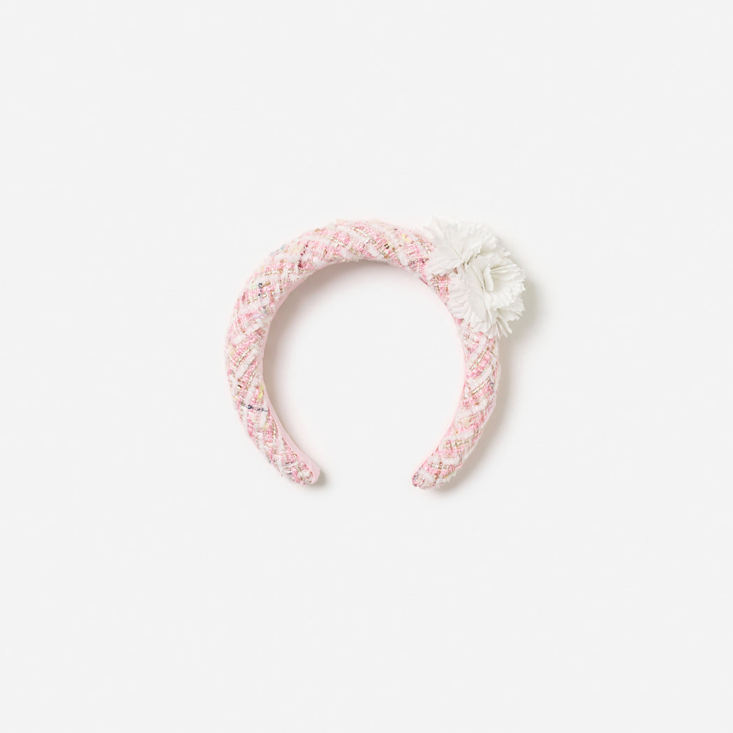 Front view of a girl wearing the Pink Boucle Flower Head Band