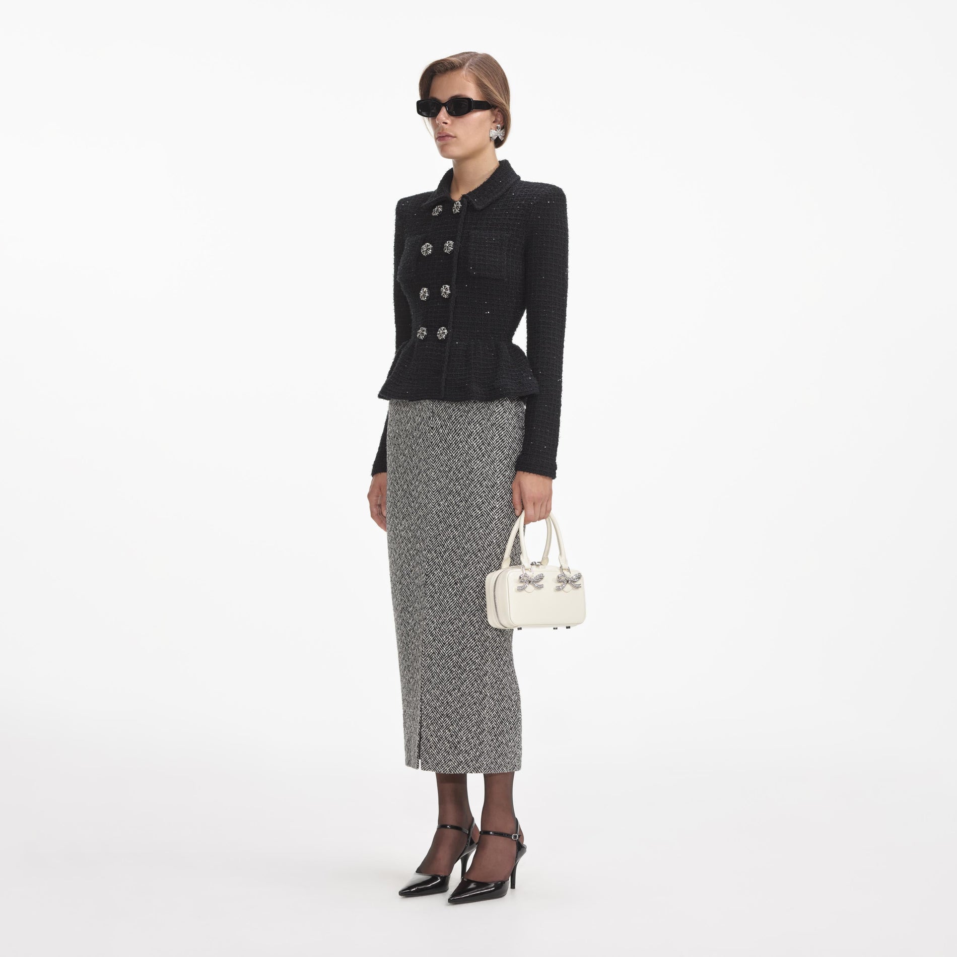 Side view of a woman wearing the Black Textured Knit Peplum Jacket