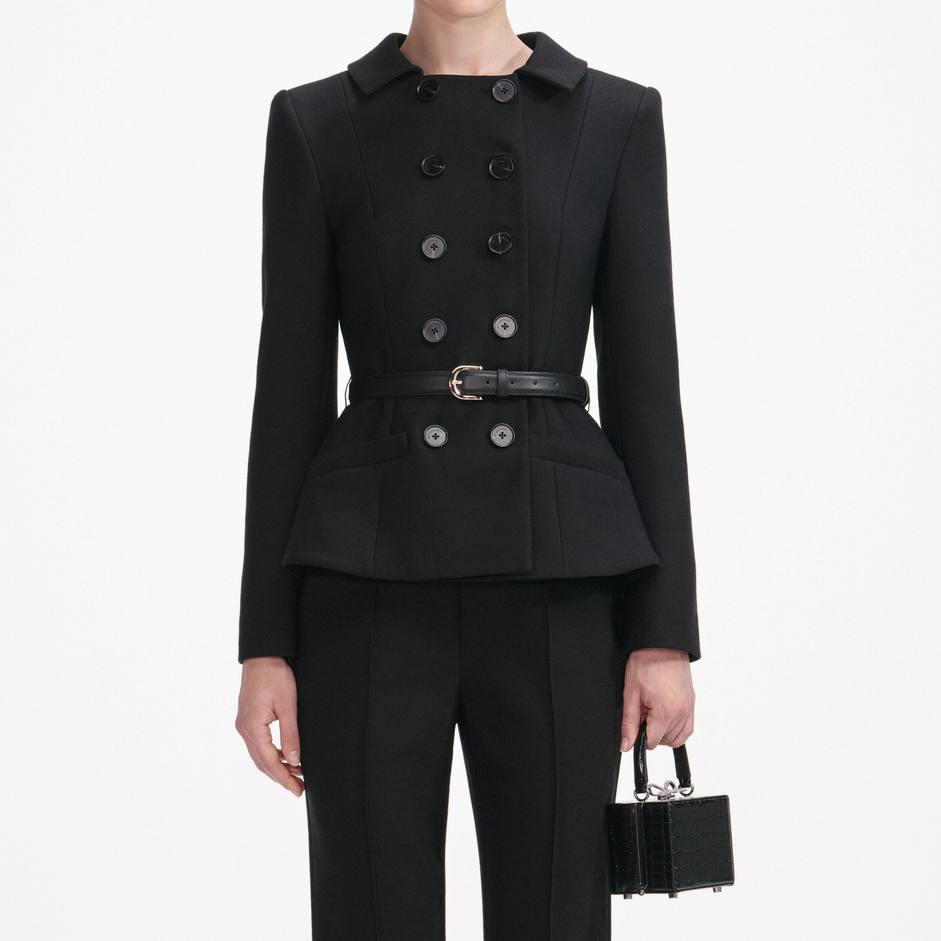 A close up of a woman wearing the Black Wool Double Breasted Jumpsuit