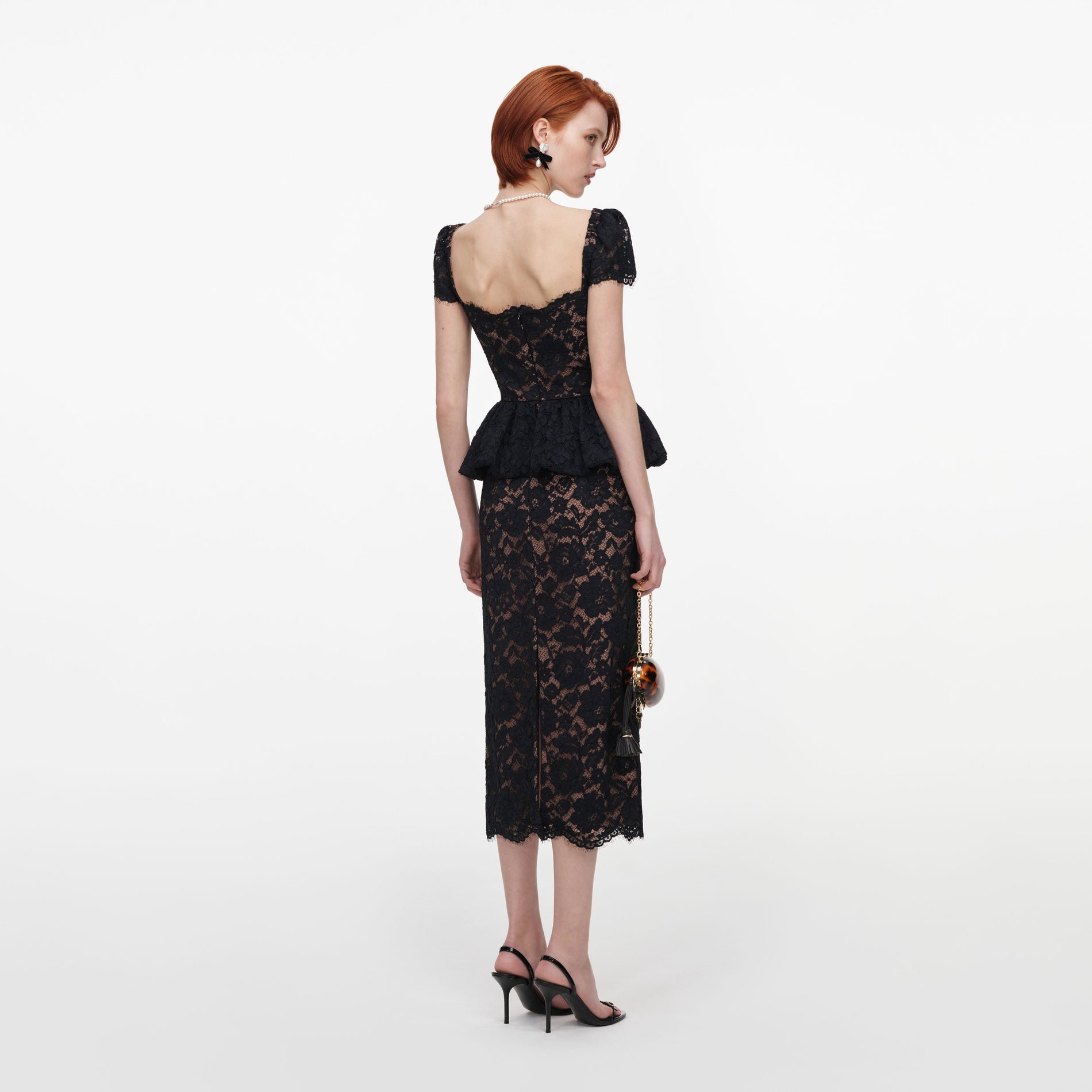 Back view of a woman wearing the Black Fine Lace Peplum Midi Dress