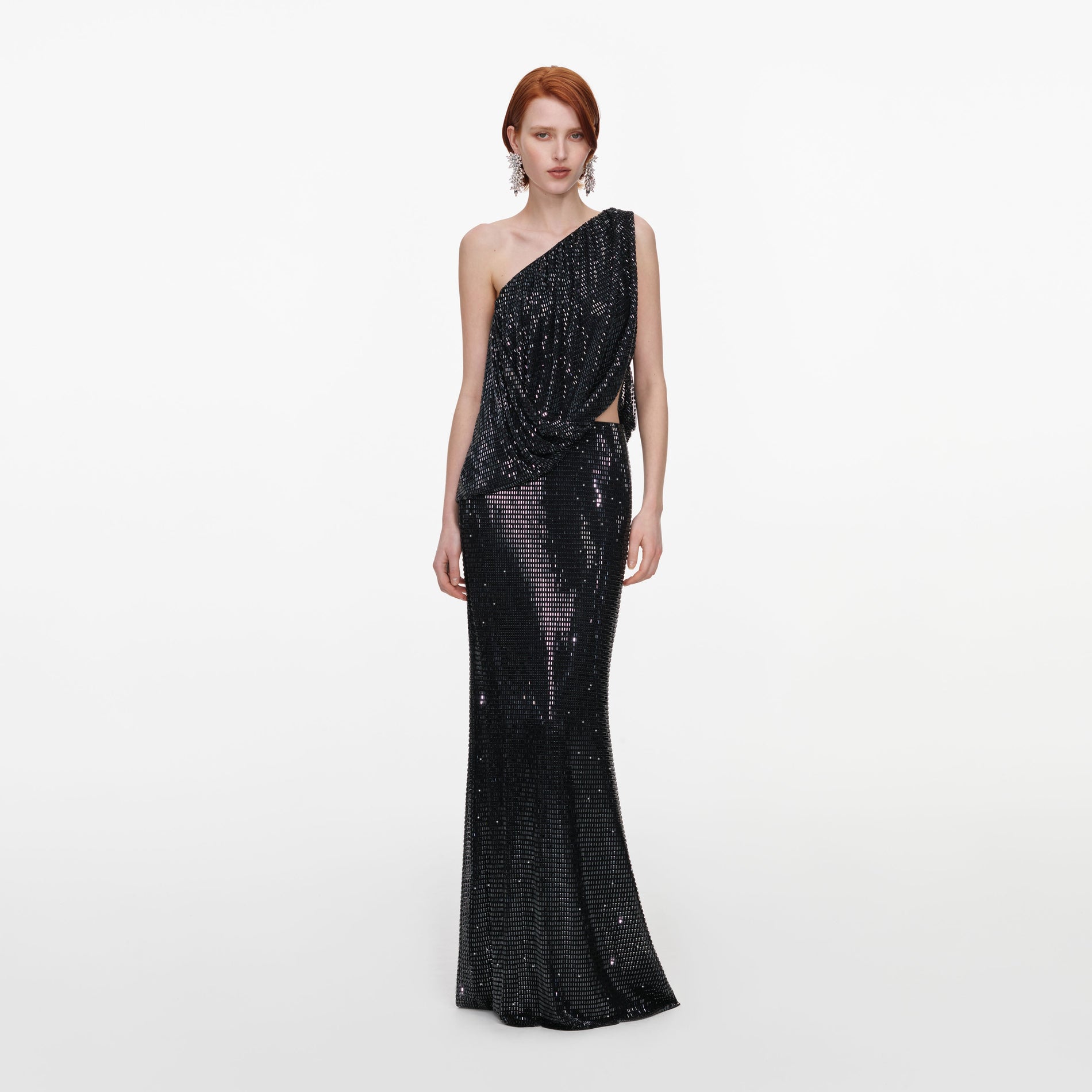 Front view of a woman wearing the Black Rhinestone One Shoulder Drape Maxi Dress