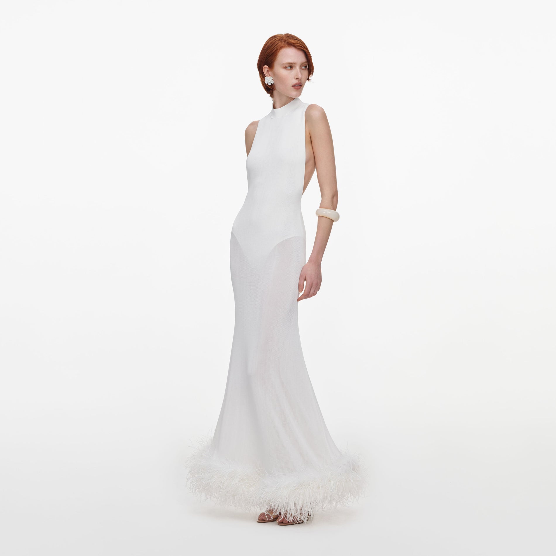 Side view of a woman wearing the White Racer Back Feather Knit Midi Dress