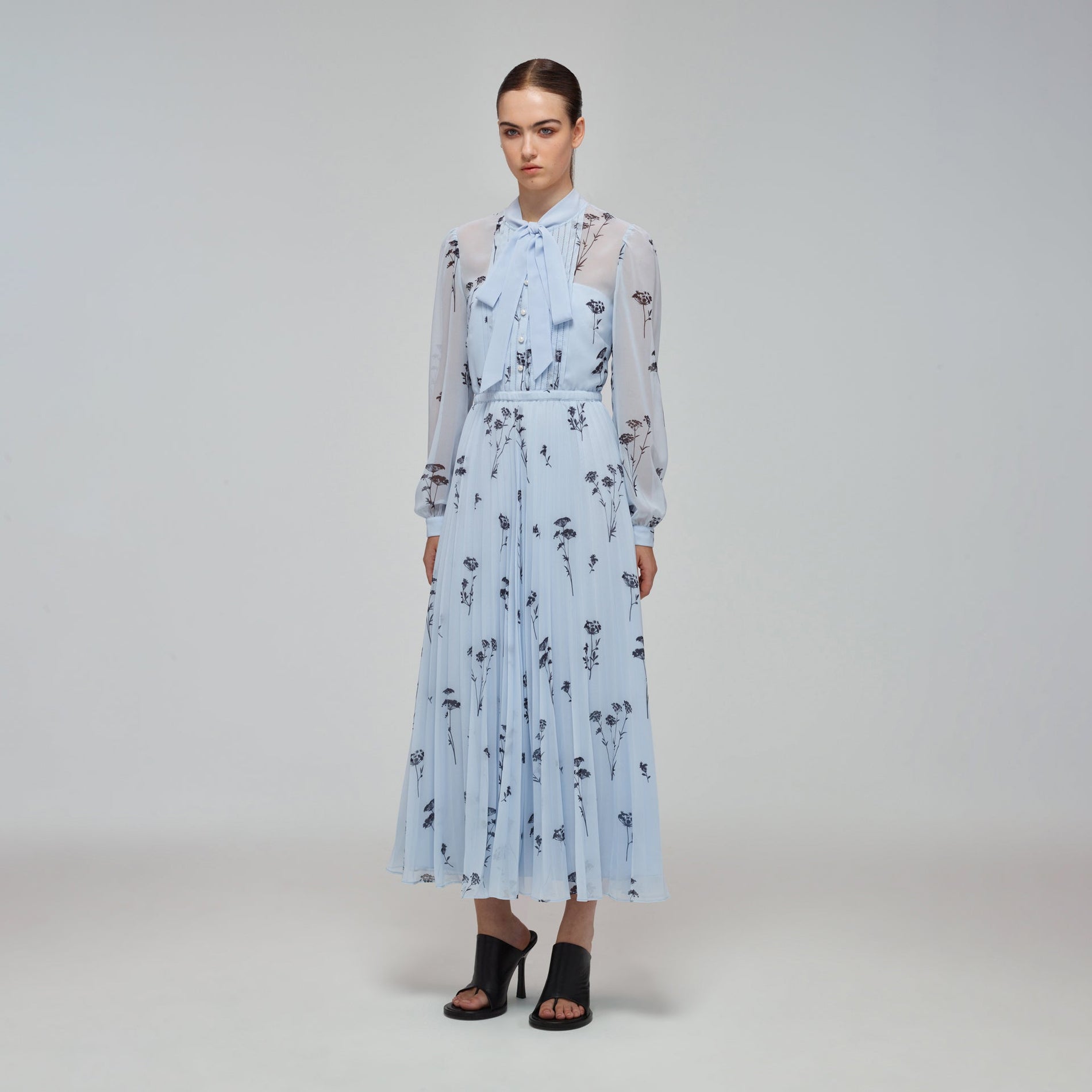 A woman wearing the Blue Floral Silhouette Chiffon Midi Dress