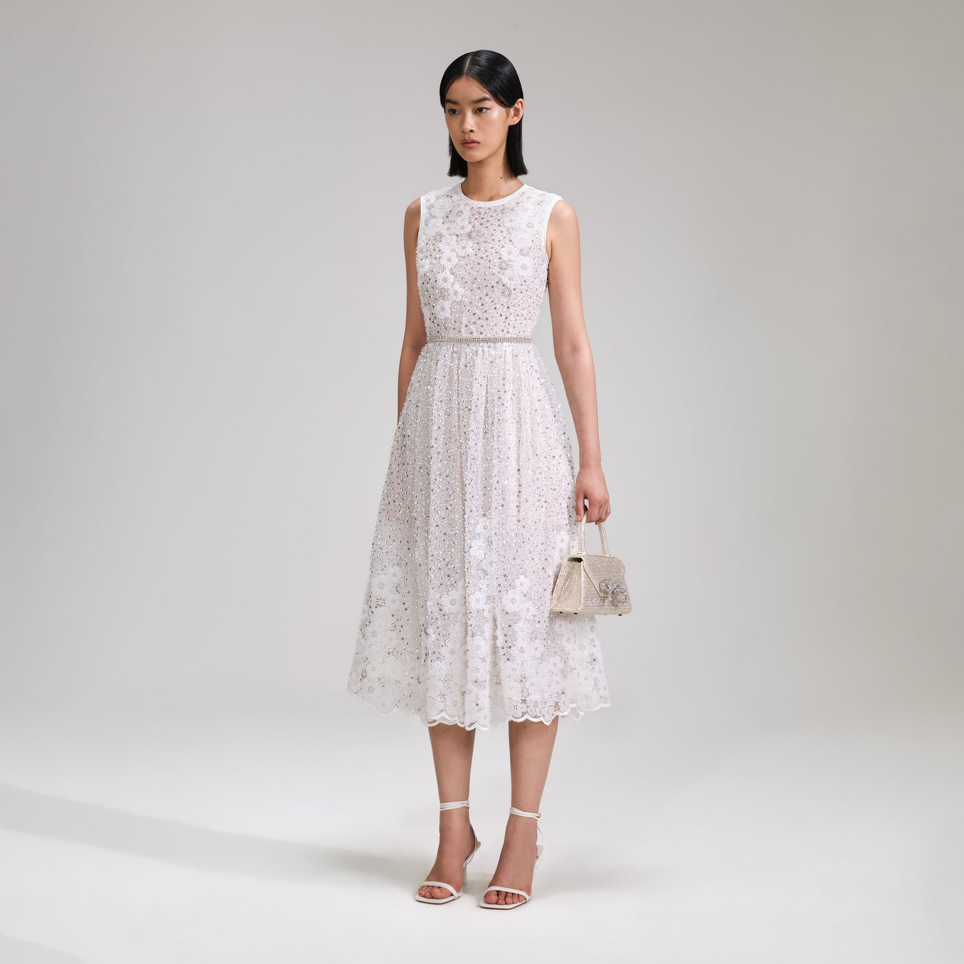 A woman wearing the White Beaded Sequin Midi Dress