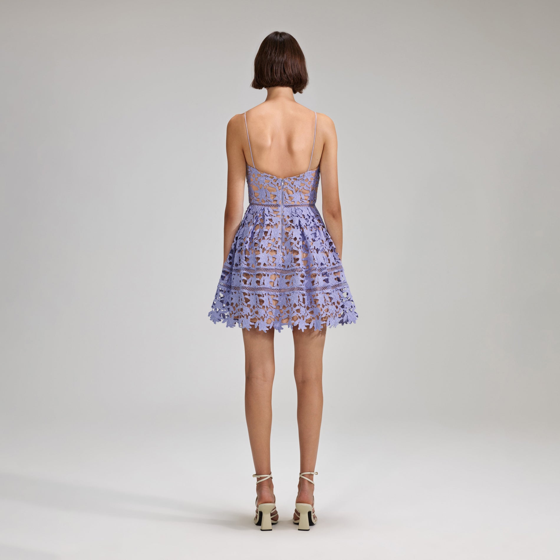 A woman wearing the Lilac Azaelea Lace Mini Dress