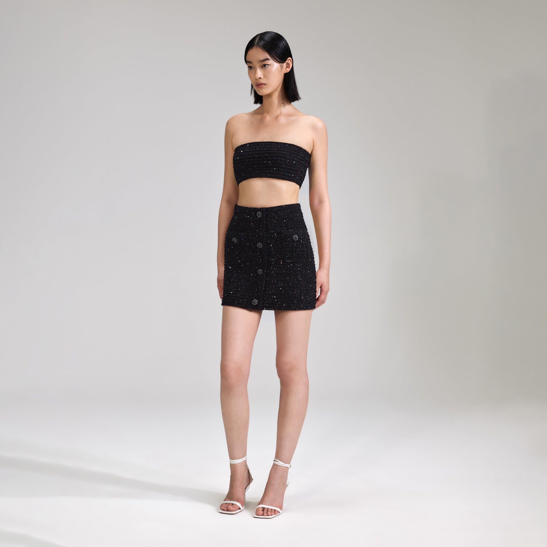 A woman wearing the Black Sequin Knit Bandeau Top