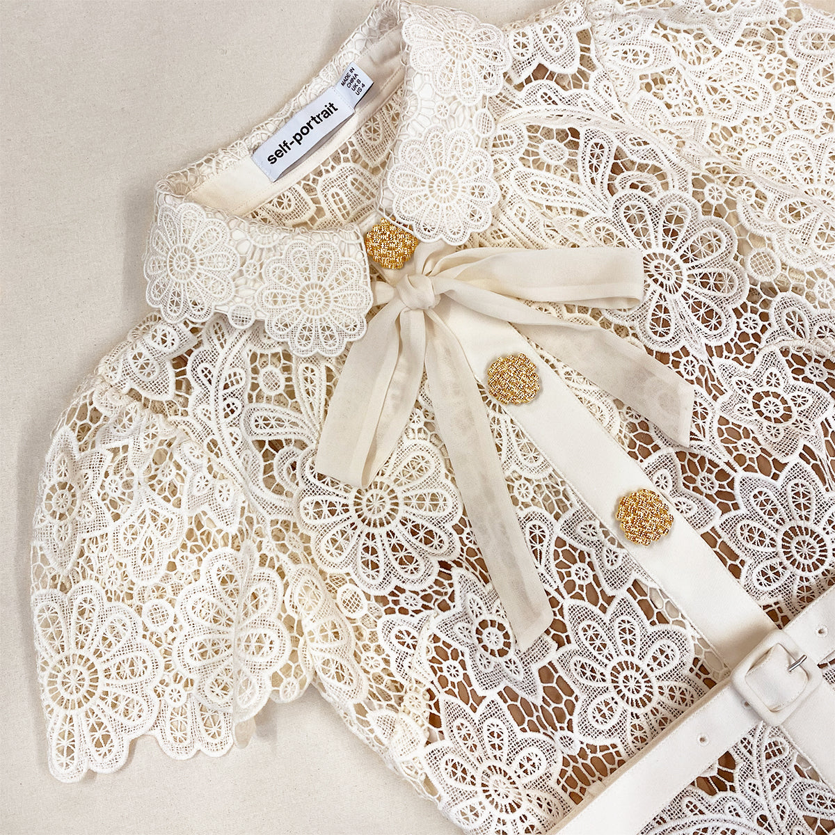 A close up of the fabric for the Cream Floral Guipure Midi Dress