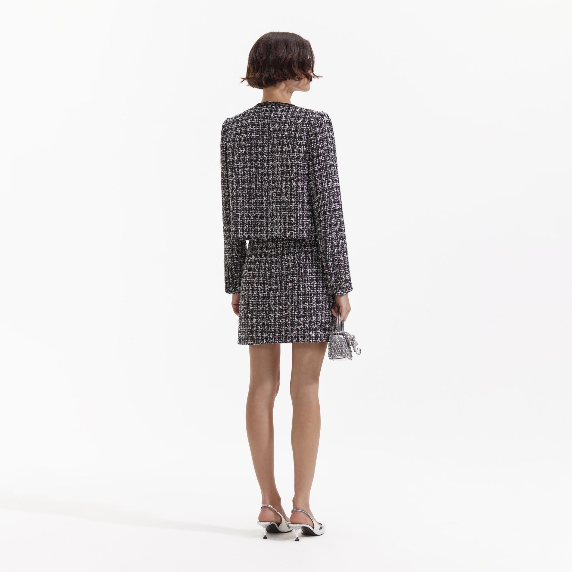 Back view of a woman wearing the Black Check Boucle Mini Skirt