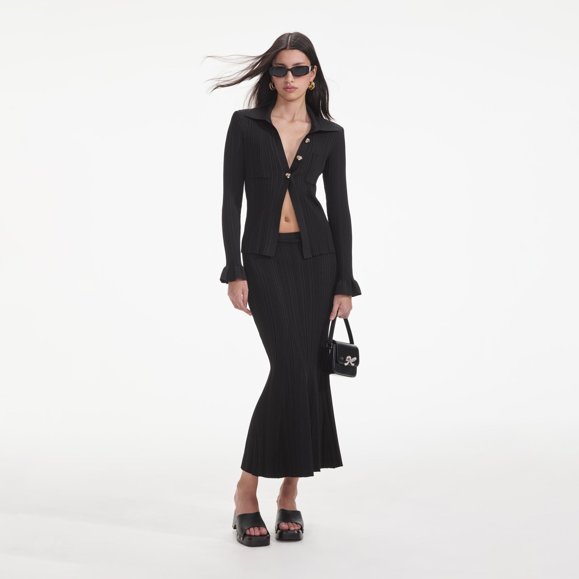 Front view of a woman wearing the Black Ribbed Midi Skirt