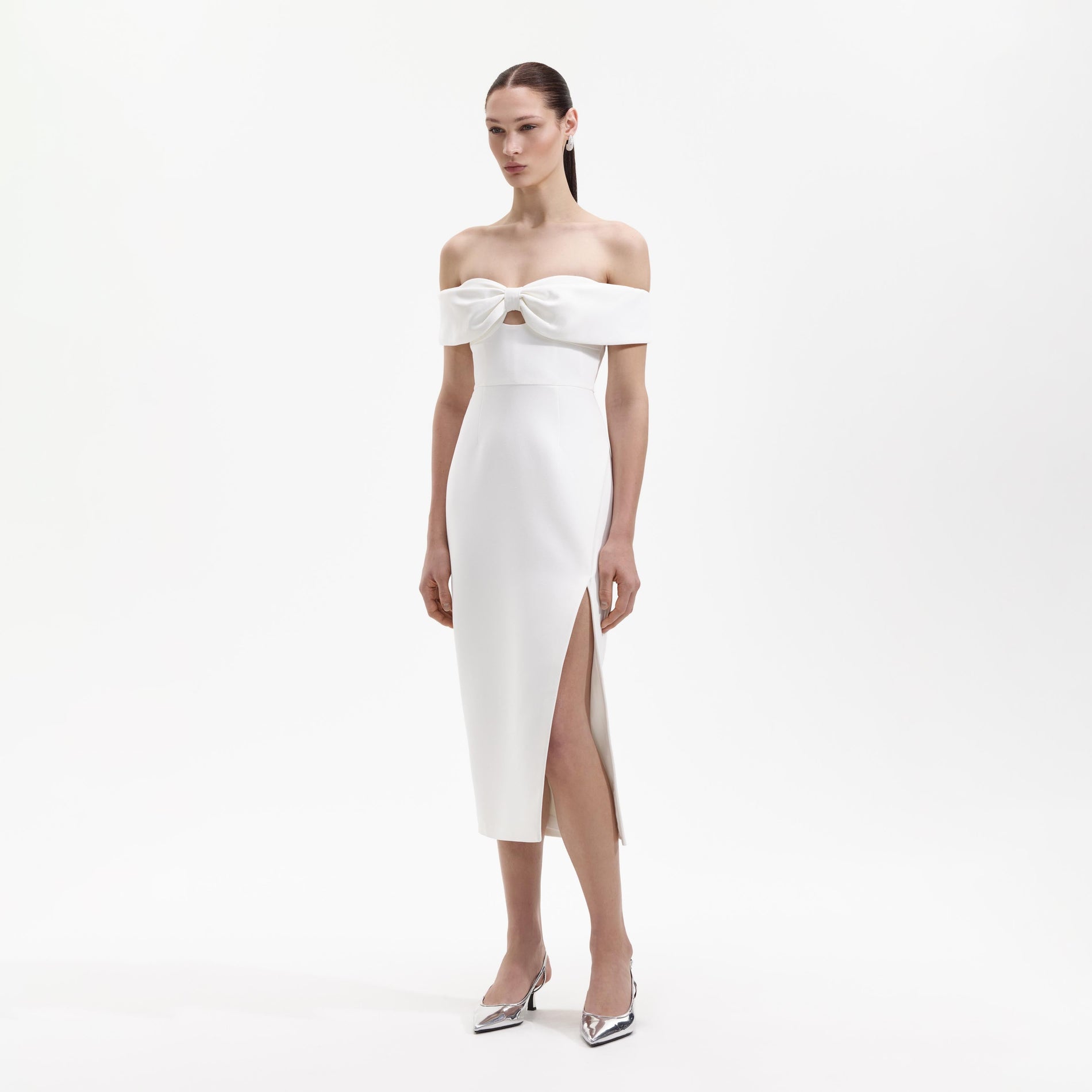 Side view of a woman wearing the White Crepe Bow Midi Dress