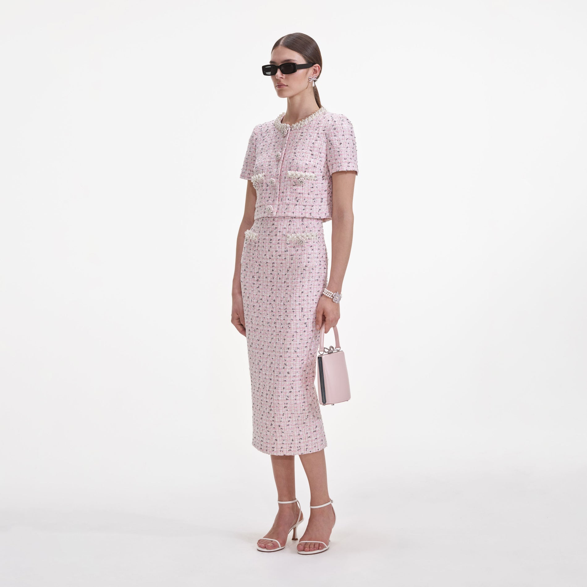 Side view of a woman wearing the Pink Boucle Pearl Midi Skirt