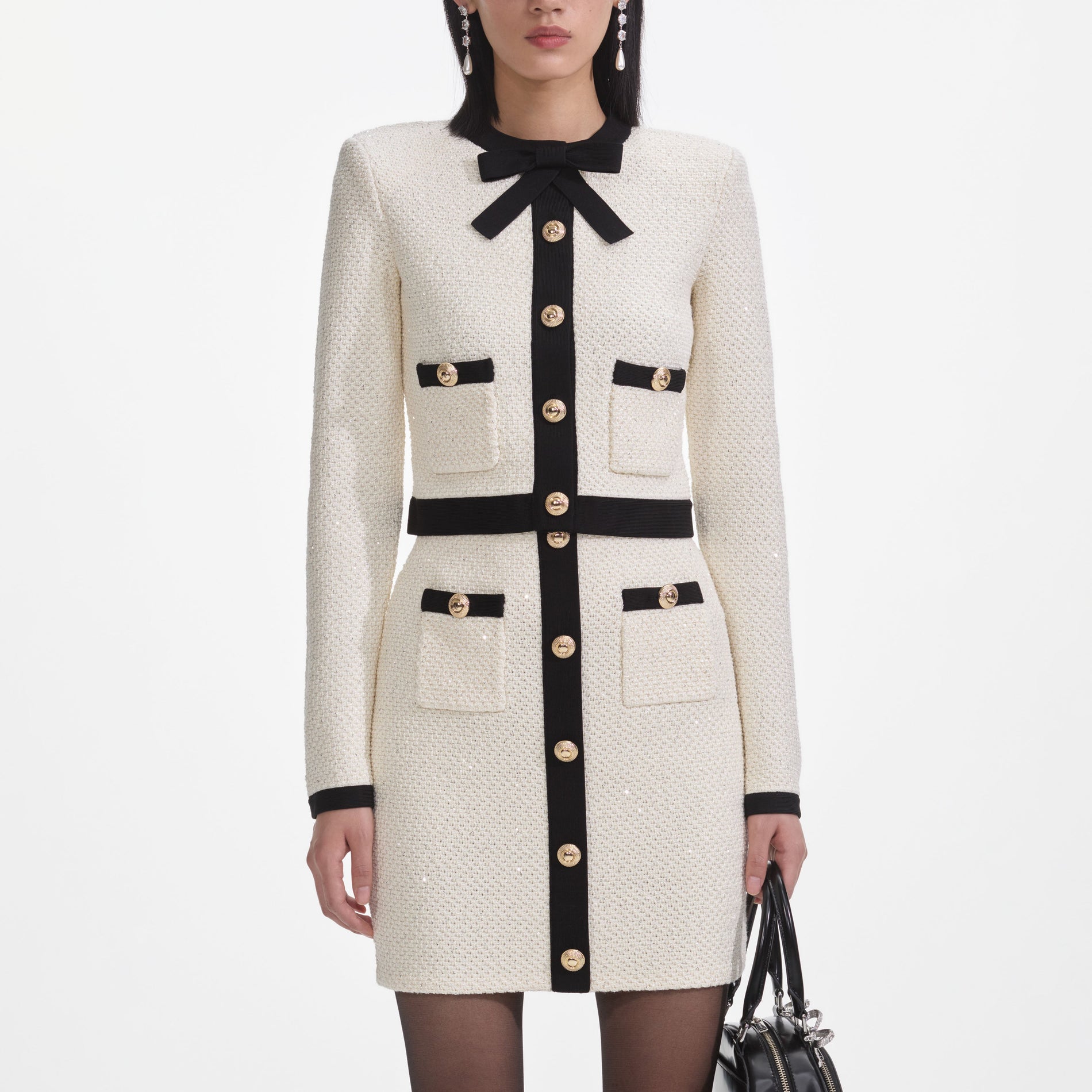 A close up of a woman wearing the Cream Sequin Knit Mini Skirt