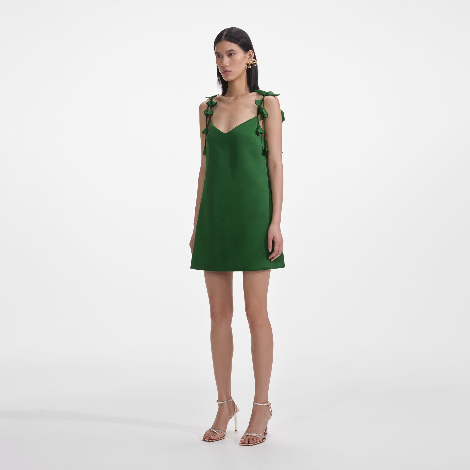 Side view of a woman wearing the Green Satin Flower Mini Dress