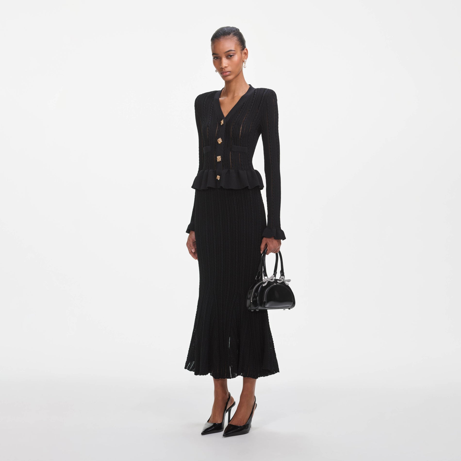 Side view of a woman wearing the Black Knit Peplum Midi Dress