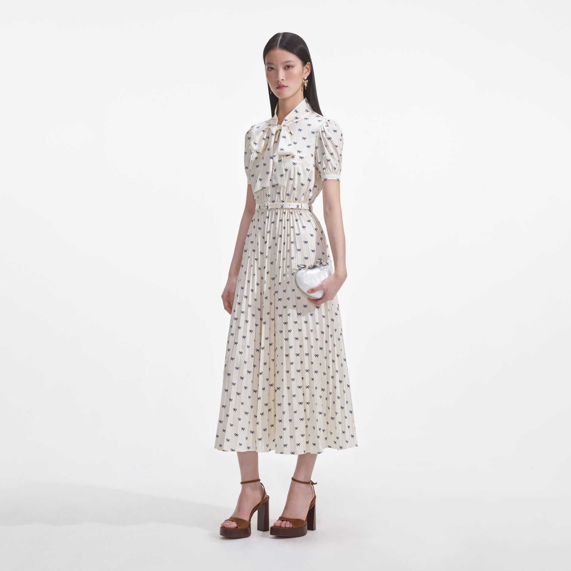 Side view of a woman wearing the Cream Satin Bow Print Midi Dress