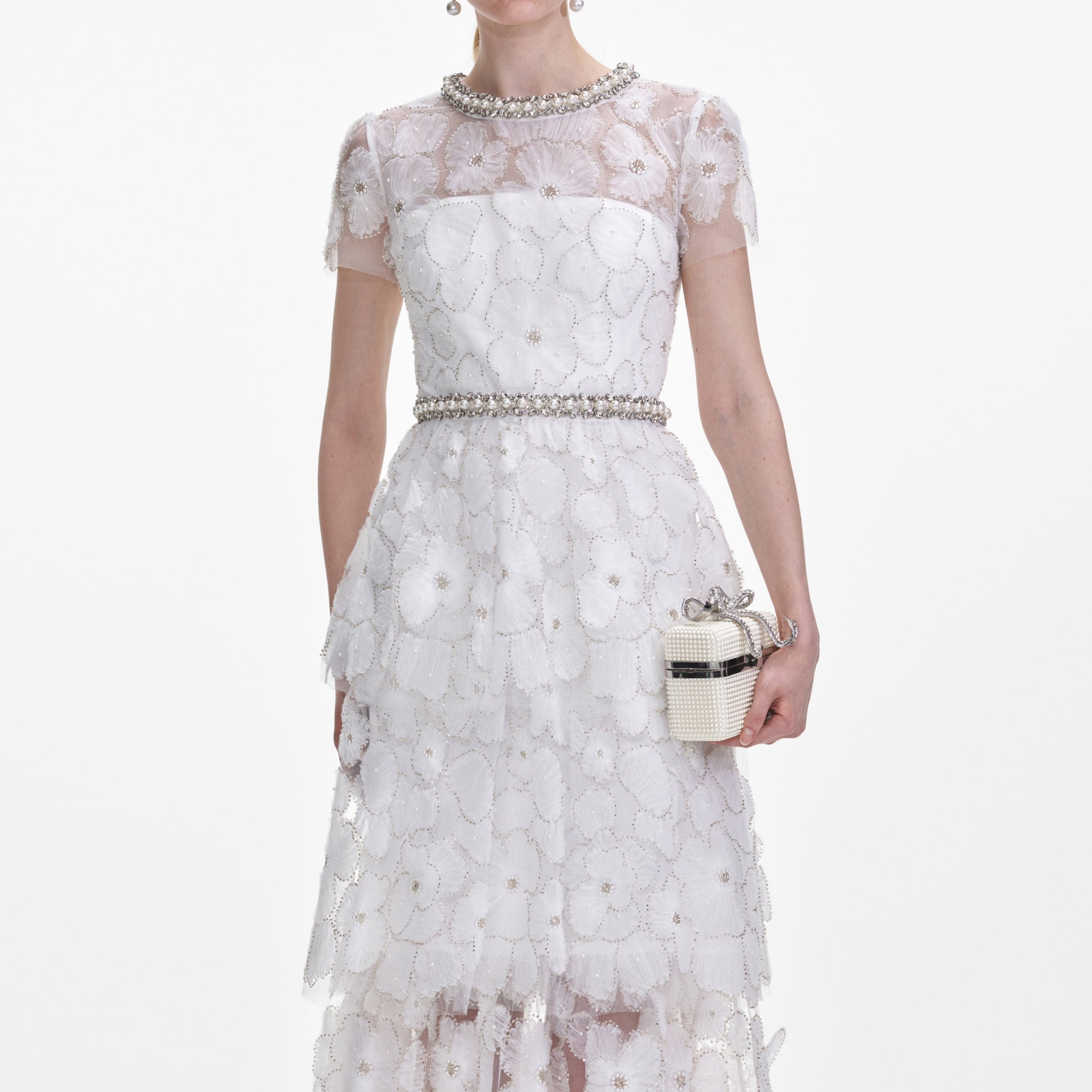 A close up of a woman wearing the White Embellished Tulle Tiered Midi Dress