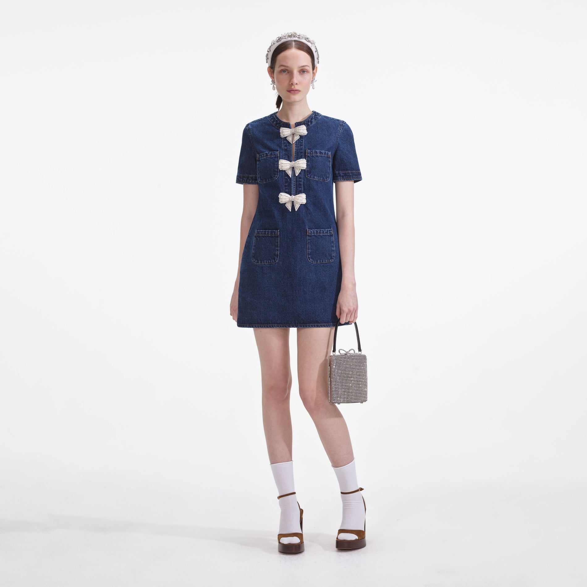 Front view of a woman wearing the Denim Bow Mini Dress