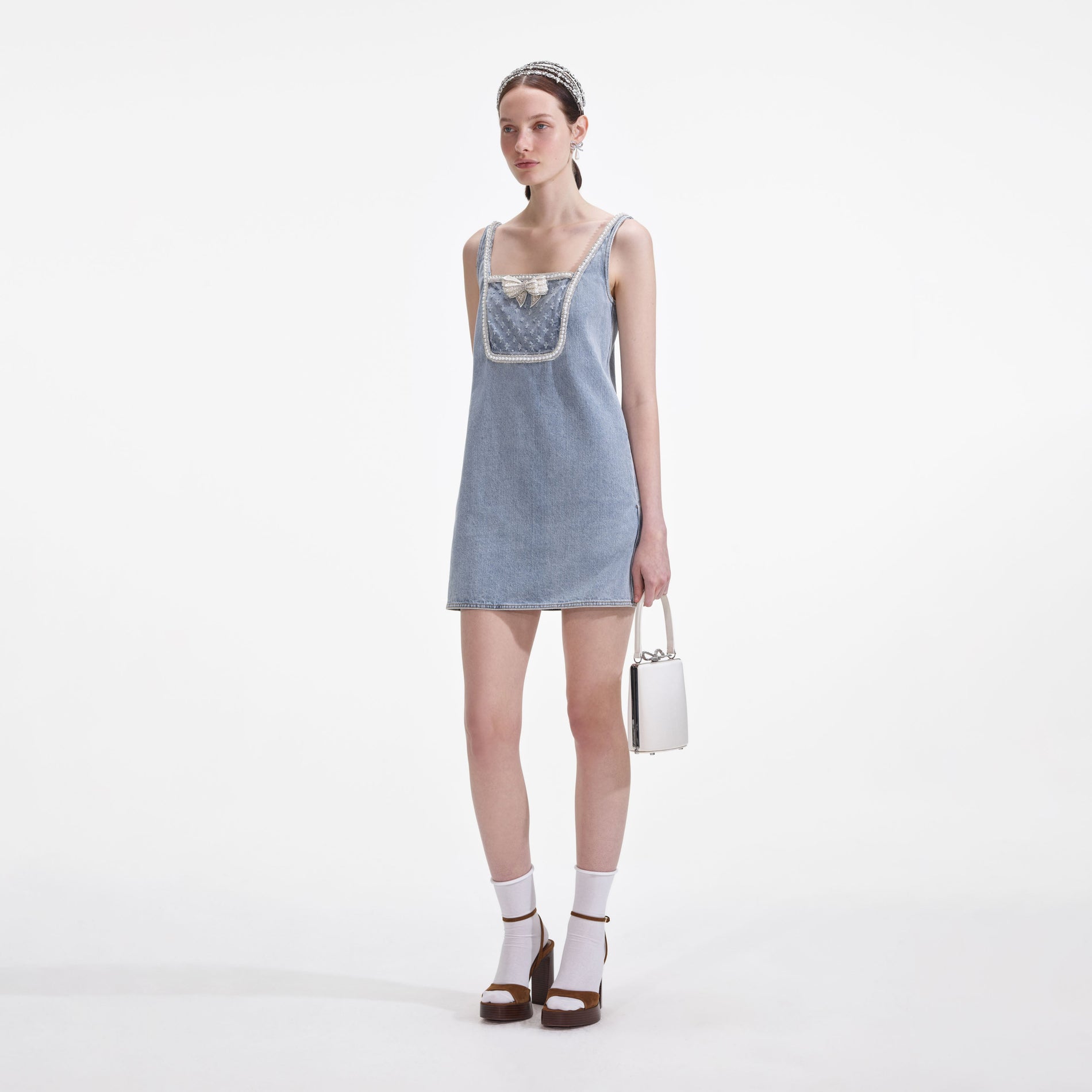 Side view of a woman wearing the Light Blue Denim Bow Mini Dress