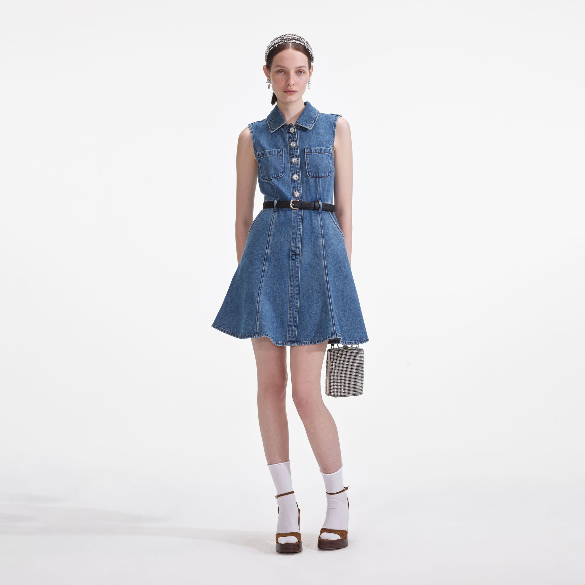 Front view of a woman wearing the Denim Sleeveless Pearl Mini Dress