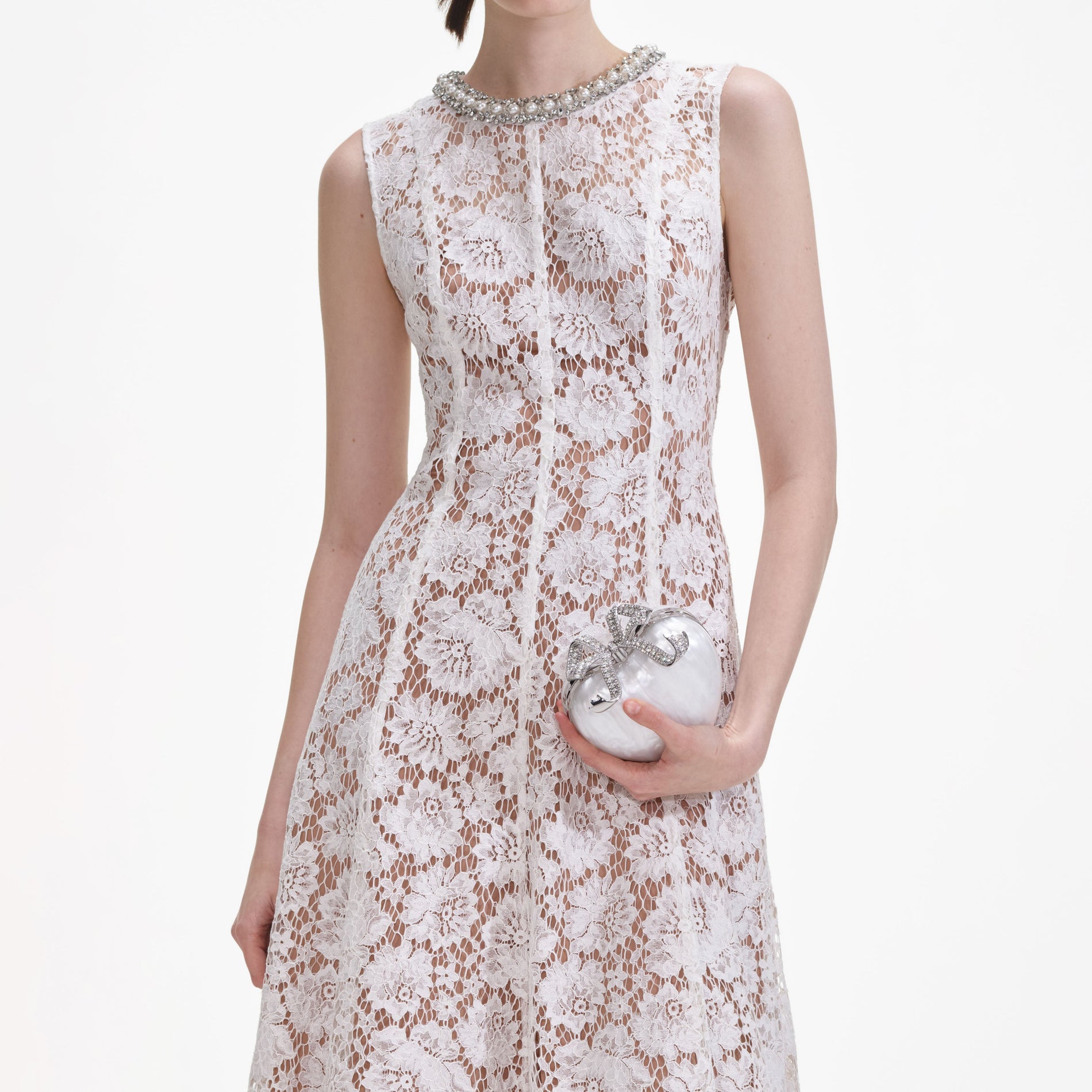 A close up of a woman wearing the White Fine Lace Pearl Midi Dress