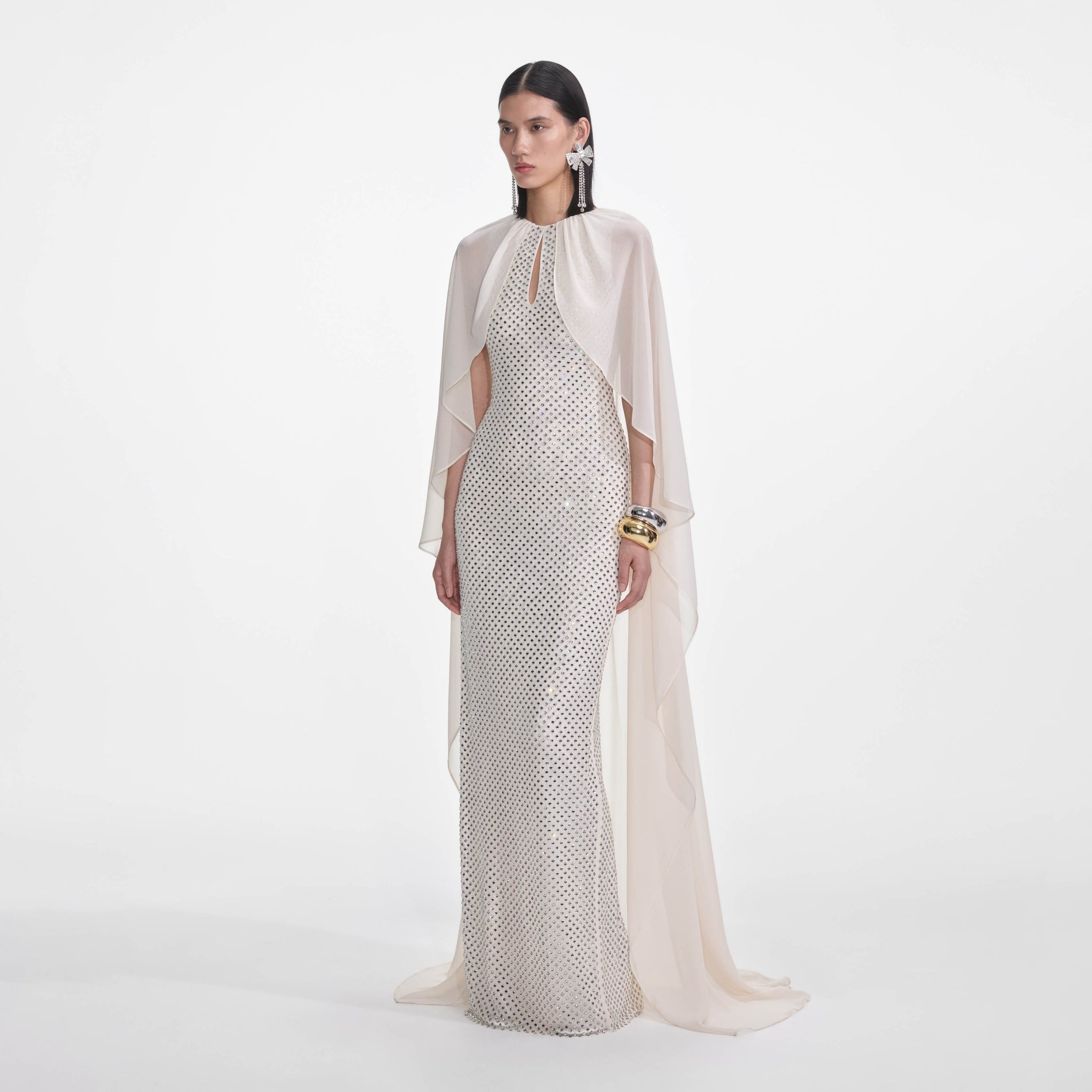 Side view of a woman wearing the Cream Rhinestone Cape Maxi Dress