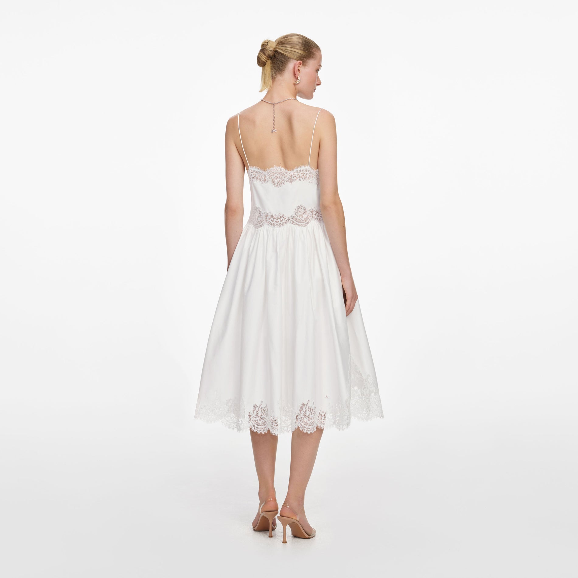 Back view of a woman wearing the White Cotton Lace Trim Midi Dress