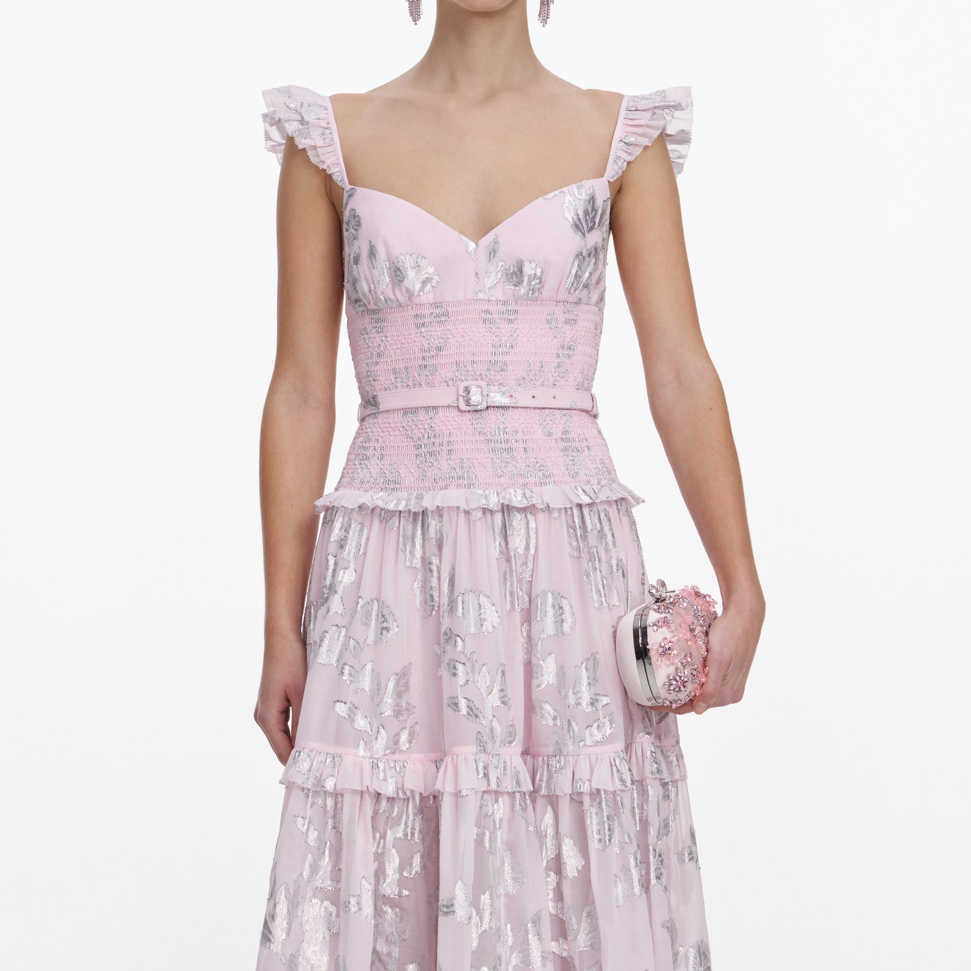 A close up of a woman wearing the Pink Metallic Chiffon Flower Maxi Dress