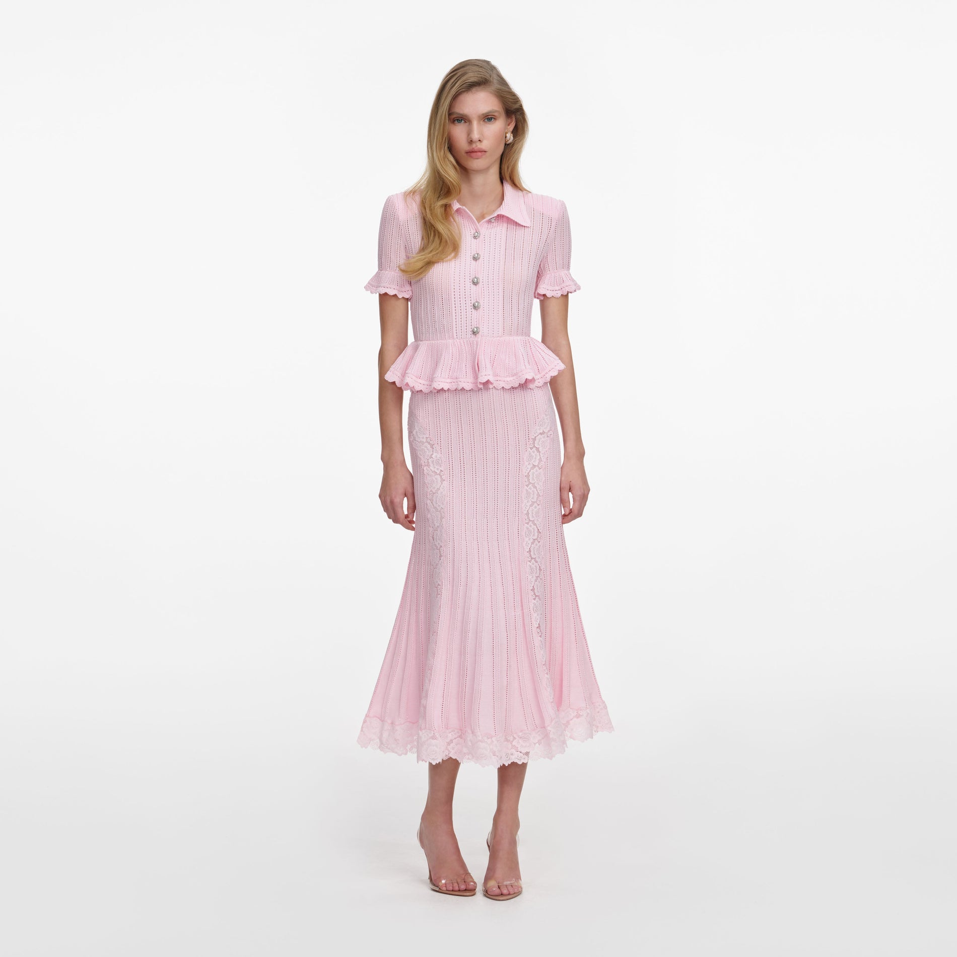 Front view of a woman wearing the Pink Pointelle Peplum Knit Midi Dress