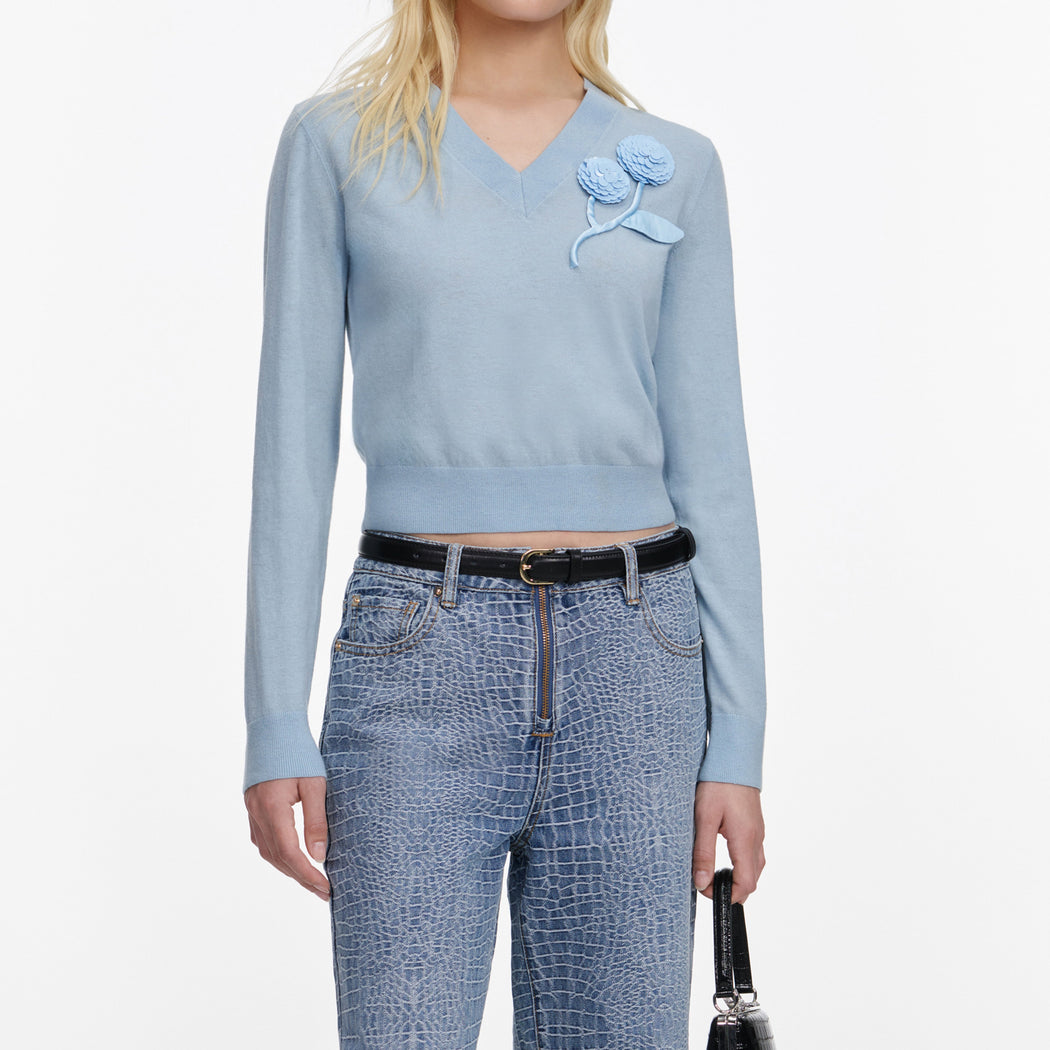 A close up of a woman wearing the Blue Rose Wool Jumper
