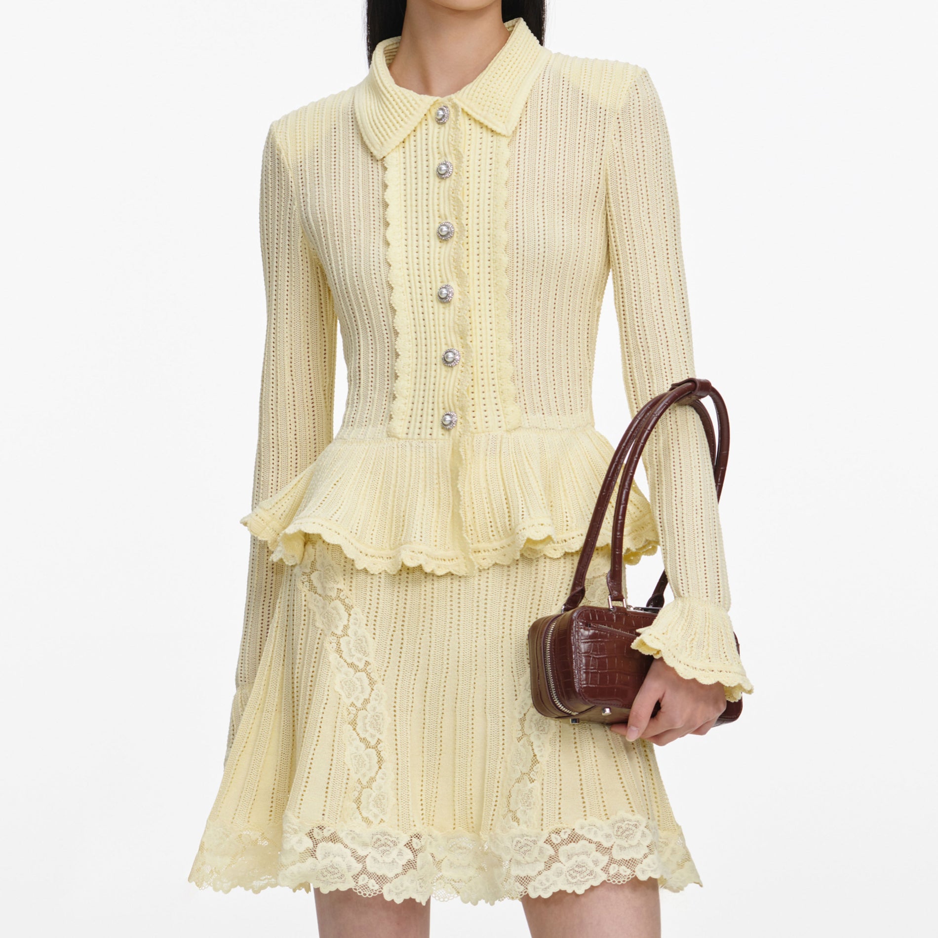 A close up of a woman wearing the Yellow Pointelle Peplum Knit Mini Dress