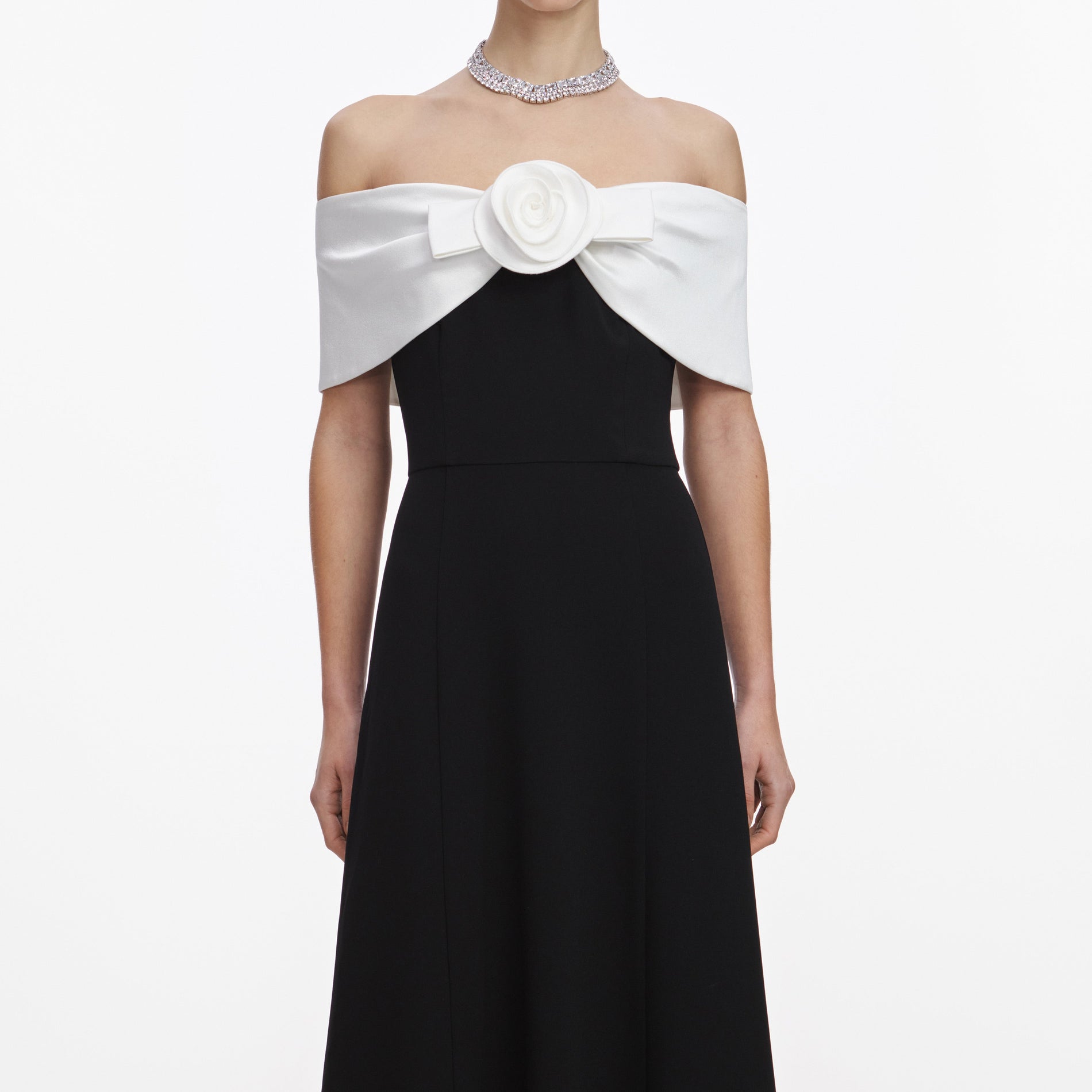 A close up of a woman wearing the Black Crepe Flower Midi Dress