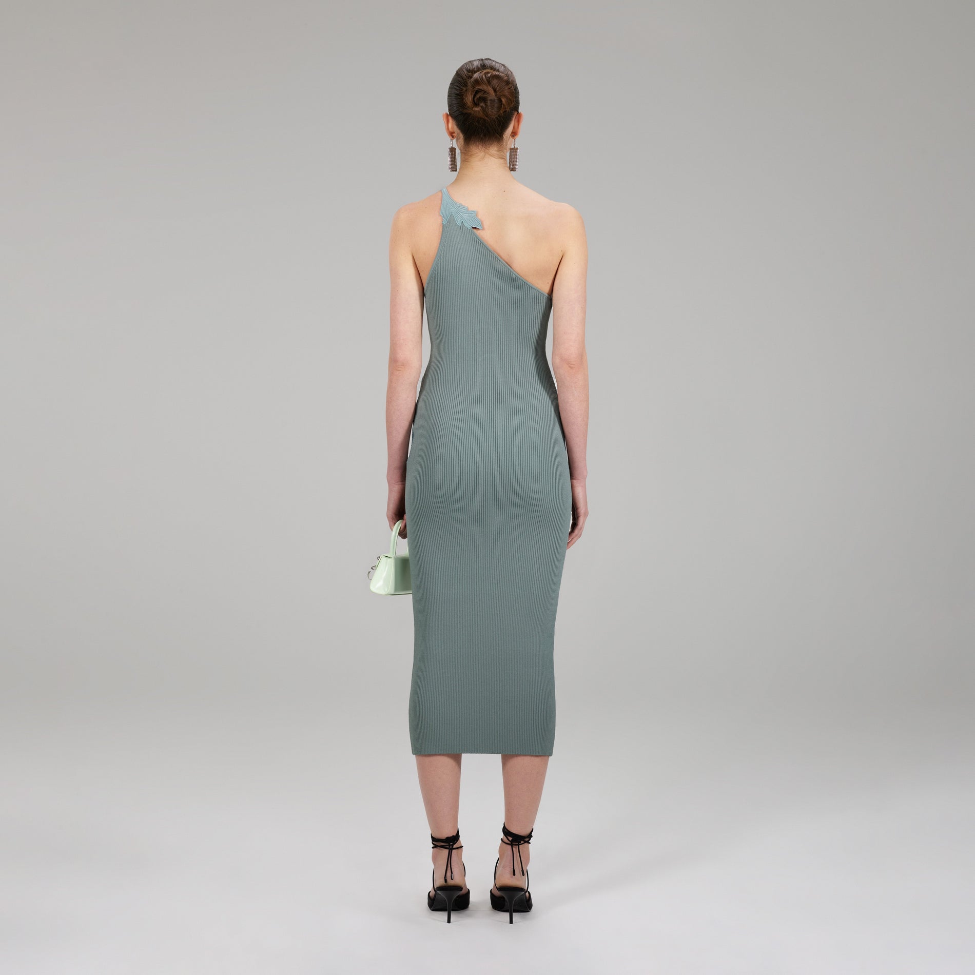 A woman wearing the Pale Green One Shoulder Ribbed Knit Dress