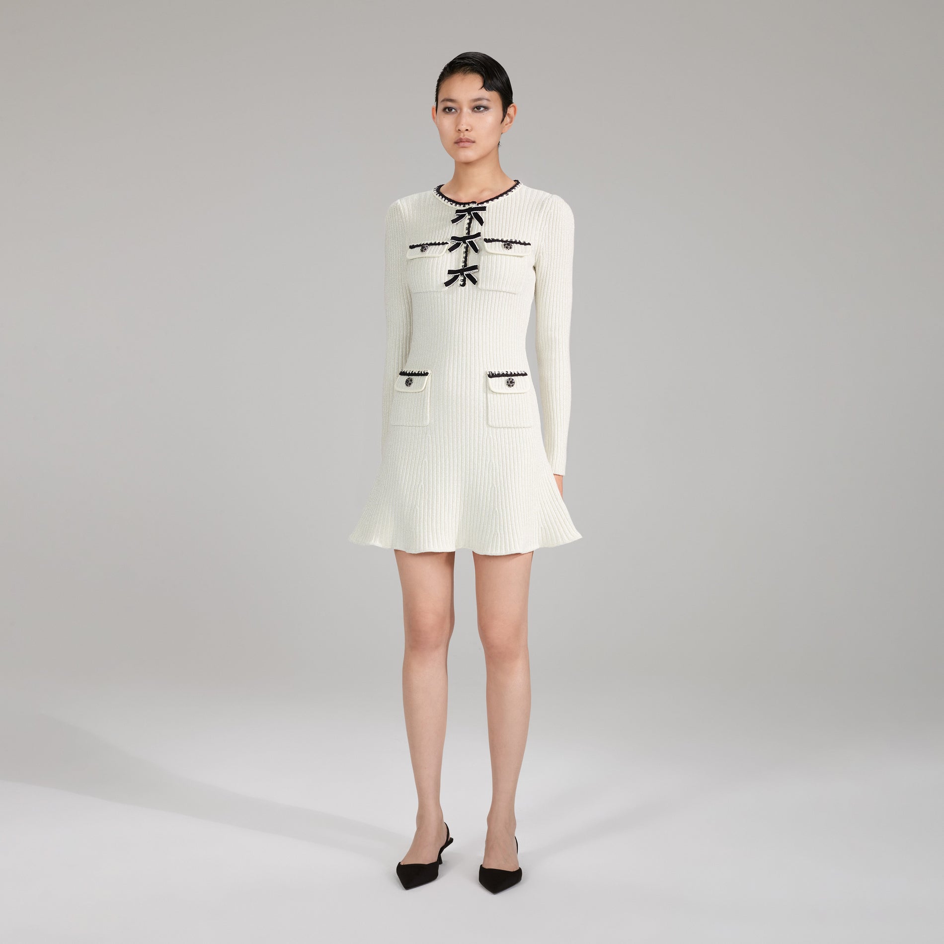 A woman wearing the Melange Long Sleeve Knit Mini Dress