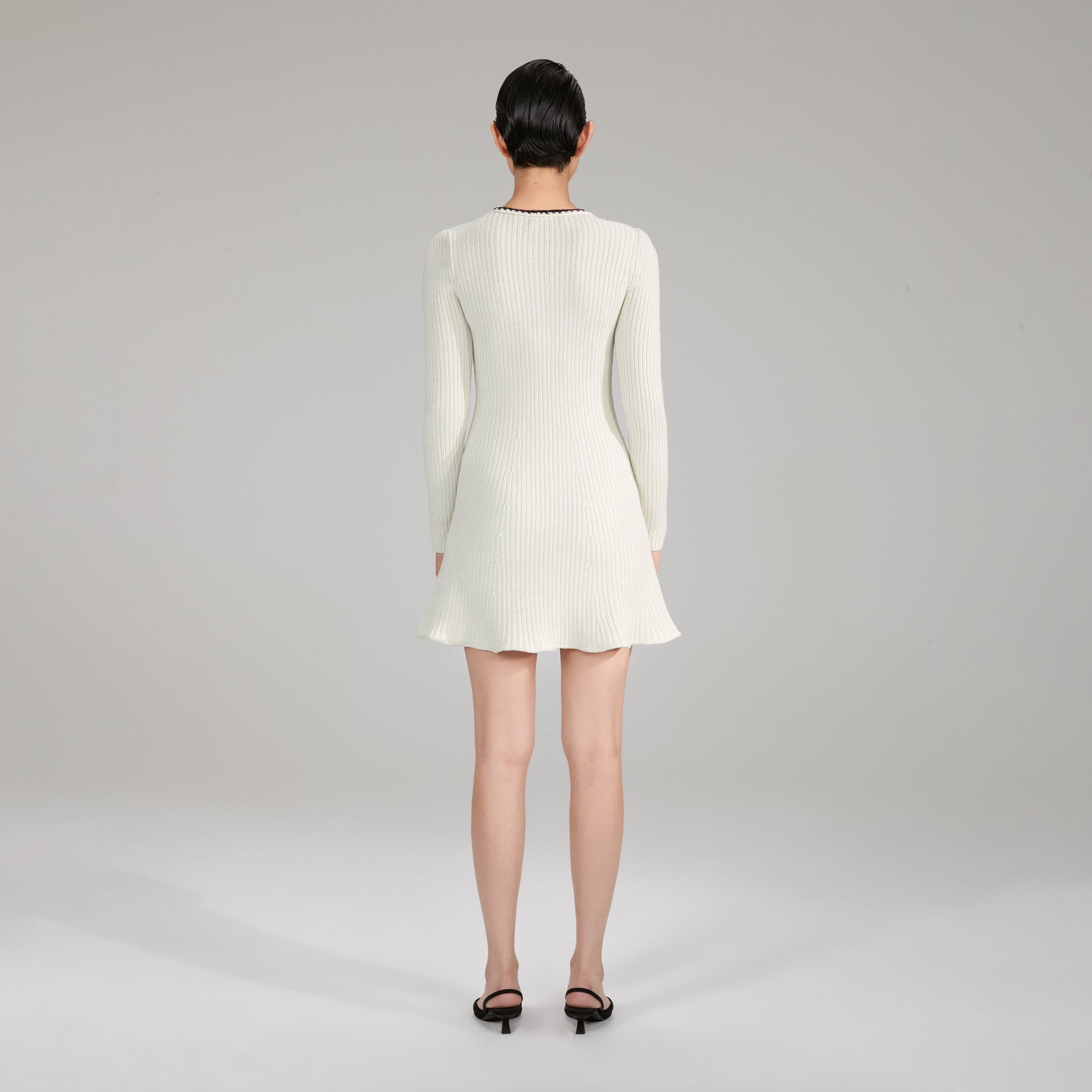 A woman wearing the Melange Long Sleeve Knit Mini Dress