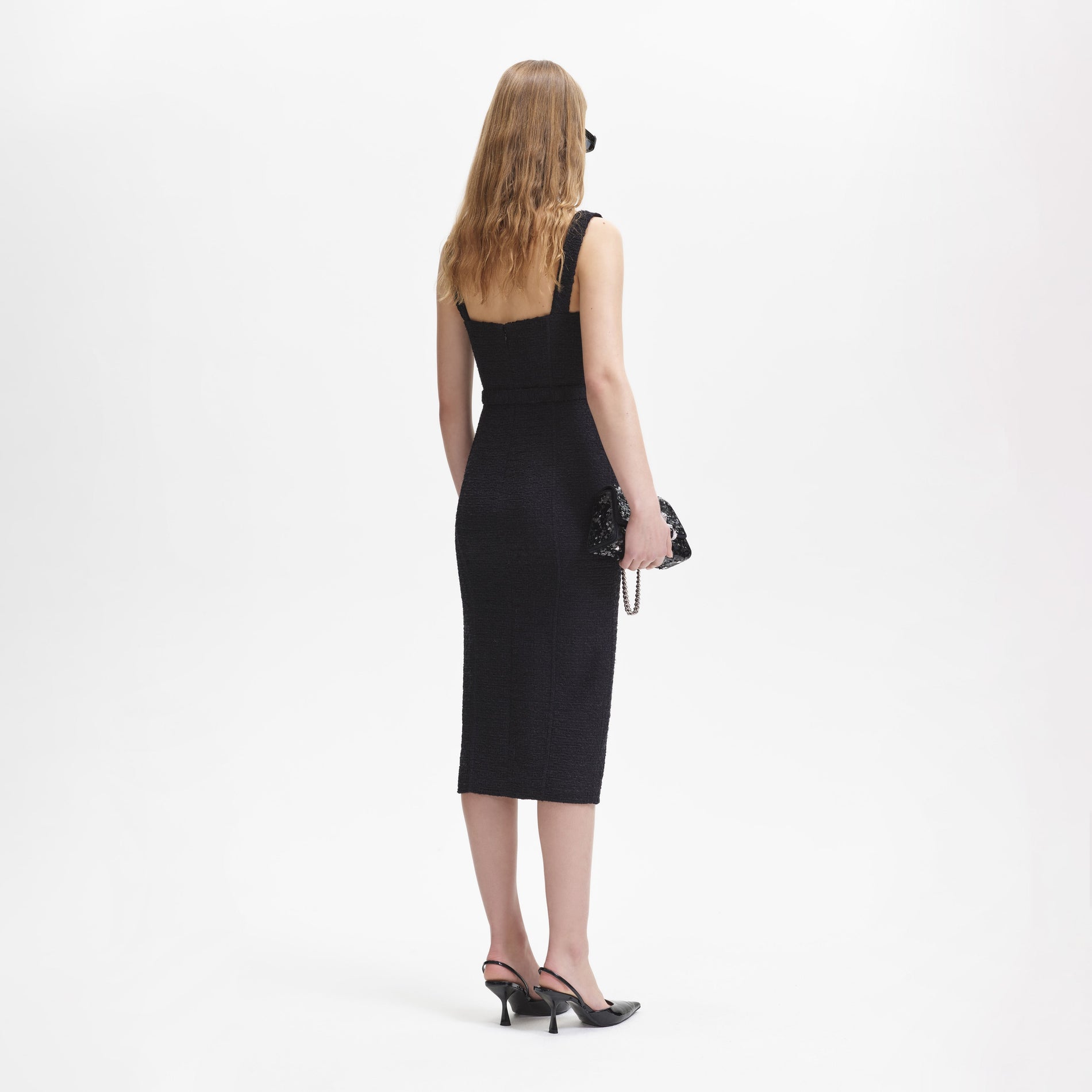 A woman wearing the Black Boucle Sweetheart Midi Dress