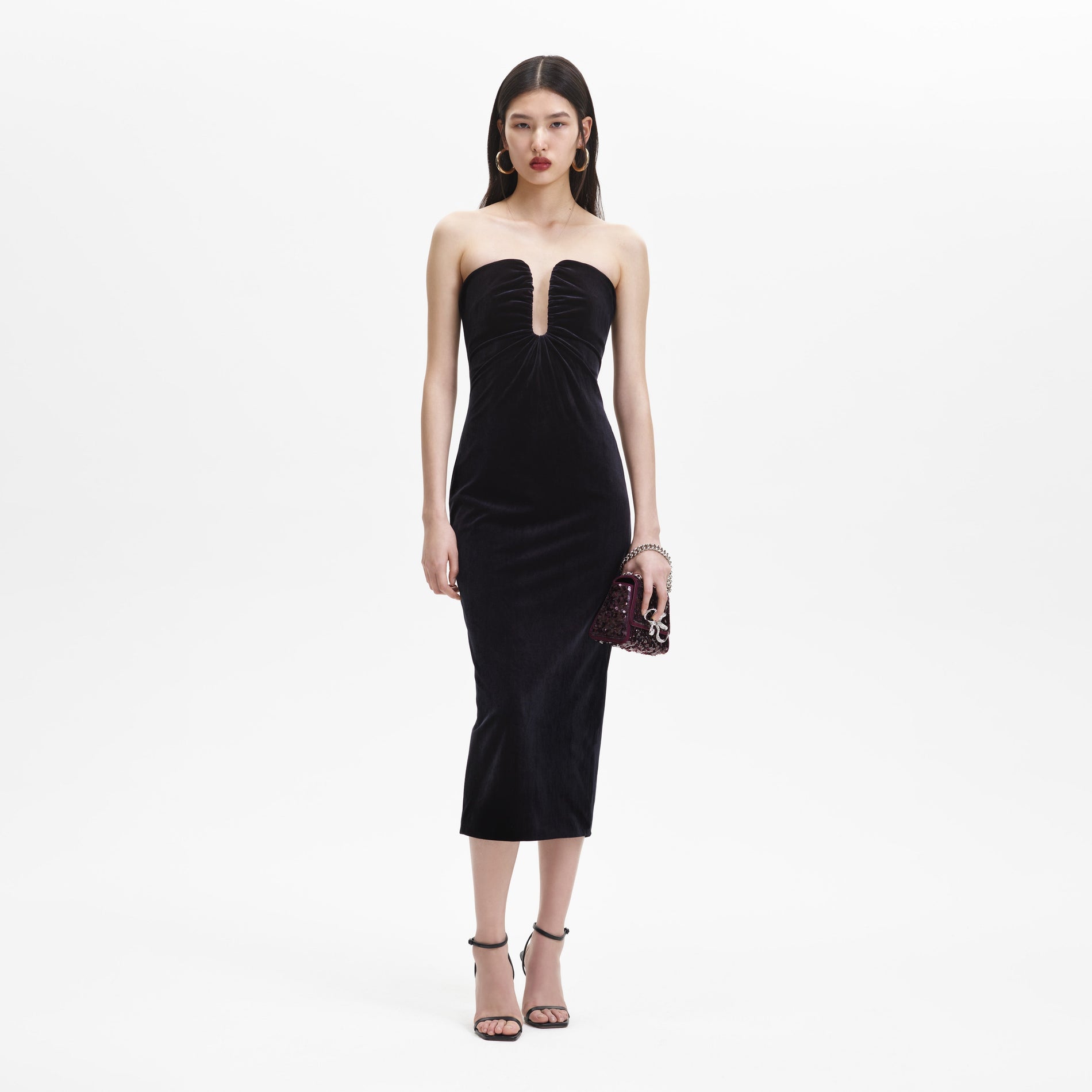 A woman wearing the Black Velvet Strapless Midi Dress