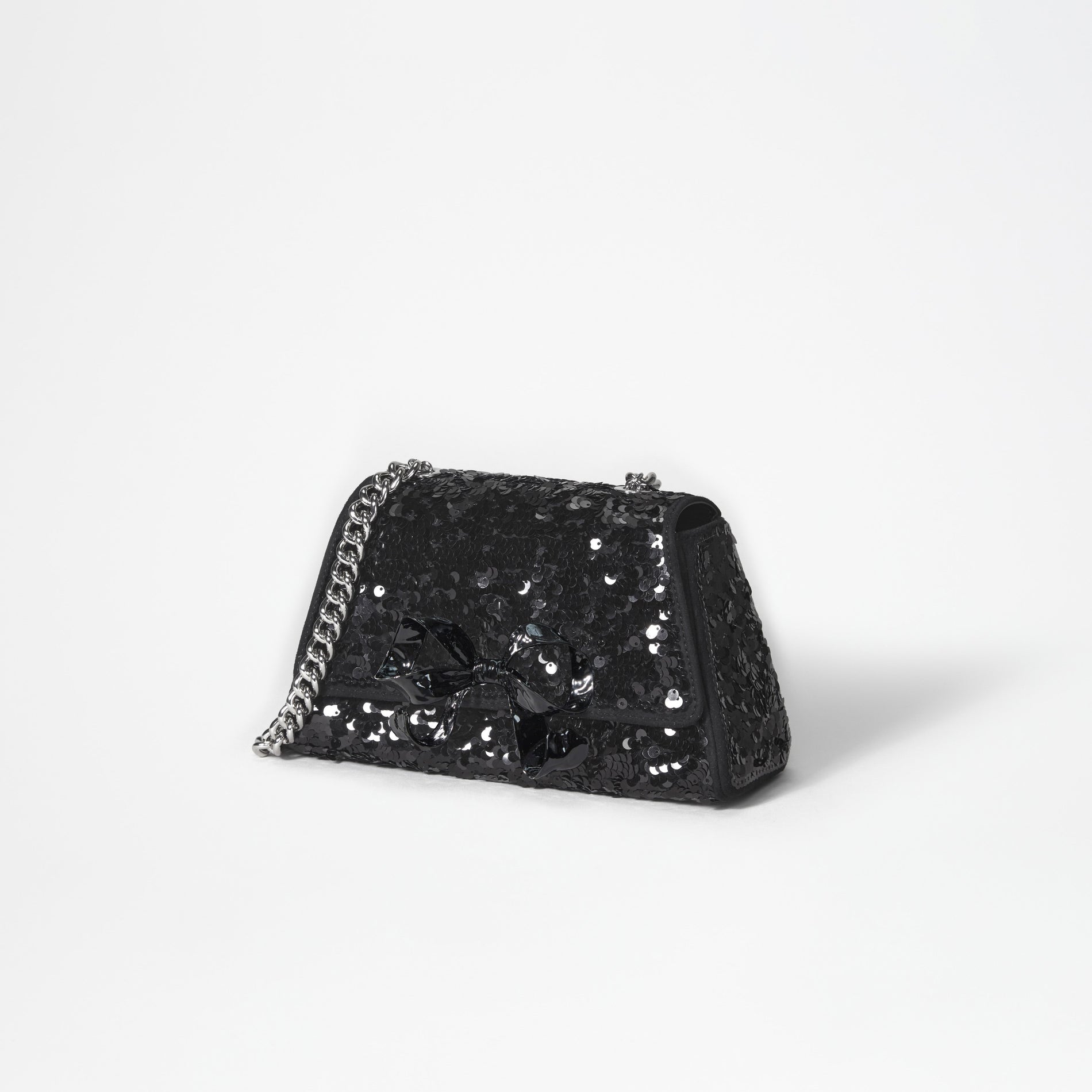 A woman wearing the Black Sequin Bow Mini Shoulder Bag
