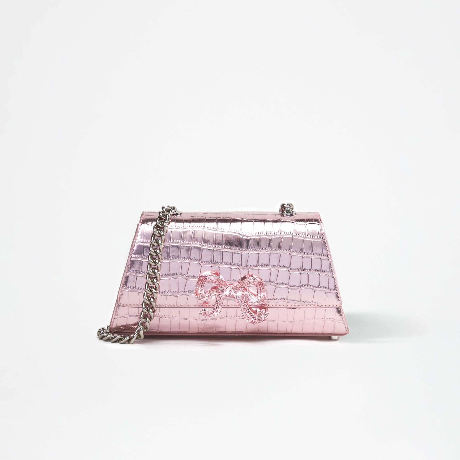 A woman wearing the Pink Metallic Bow Mini Shoulder Bag