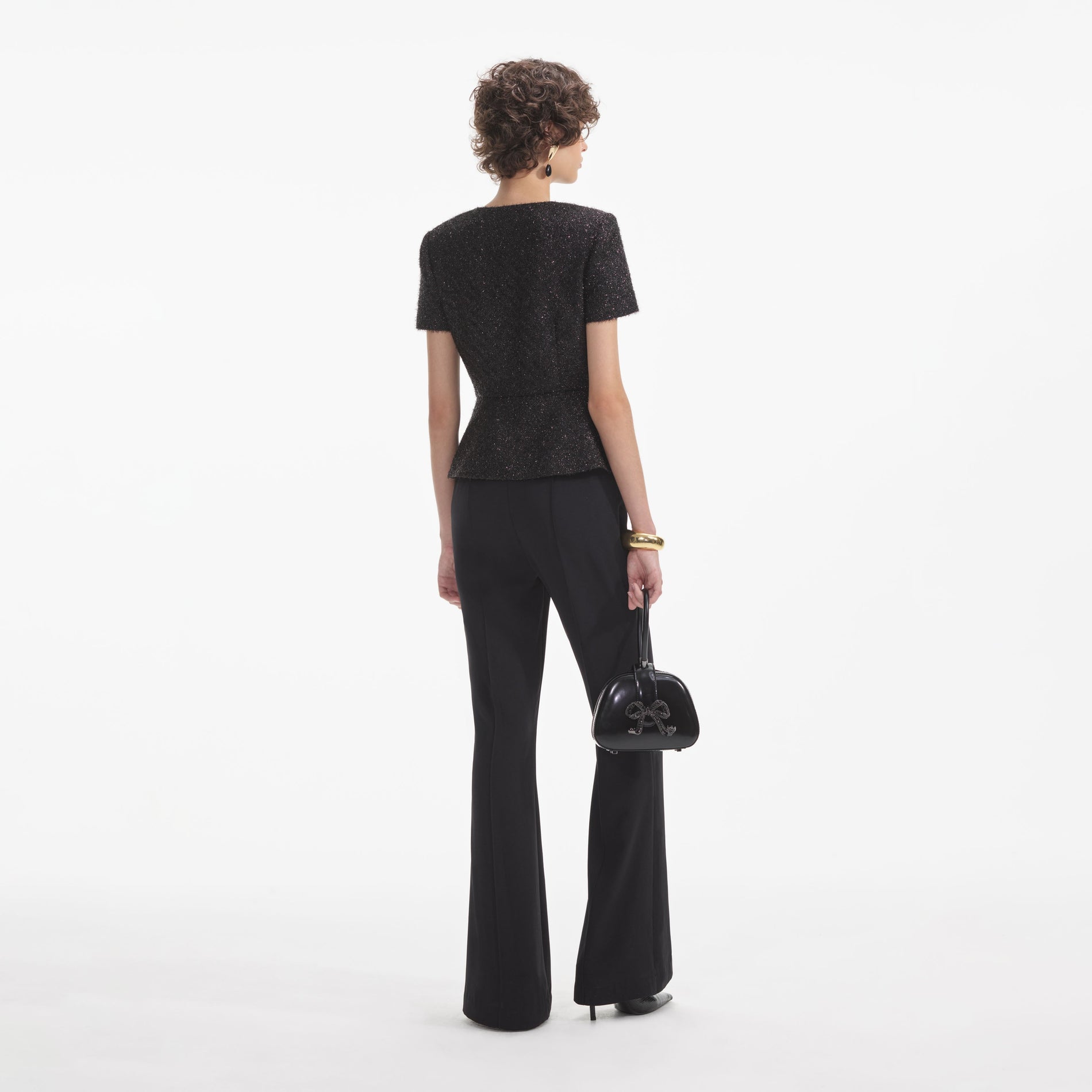 Back view of a woman wearing the White Black Tinsel Boucle Jumpsuit