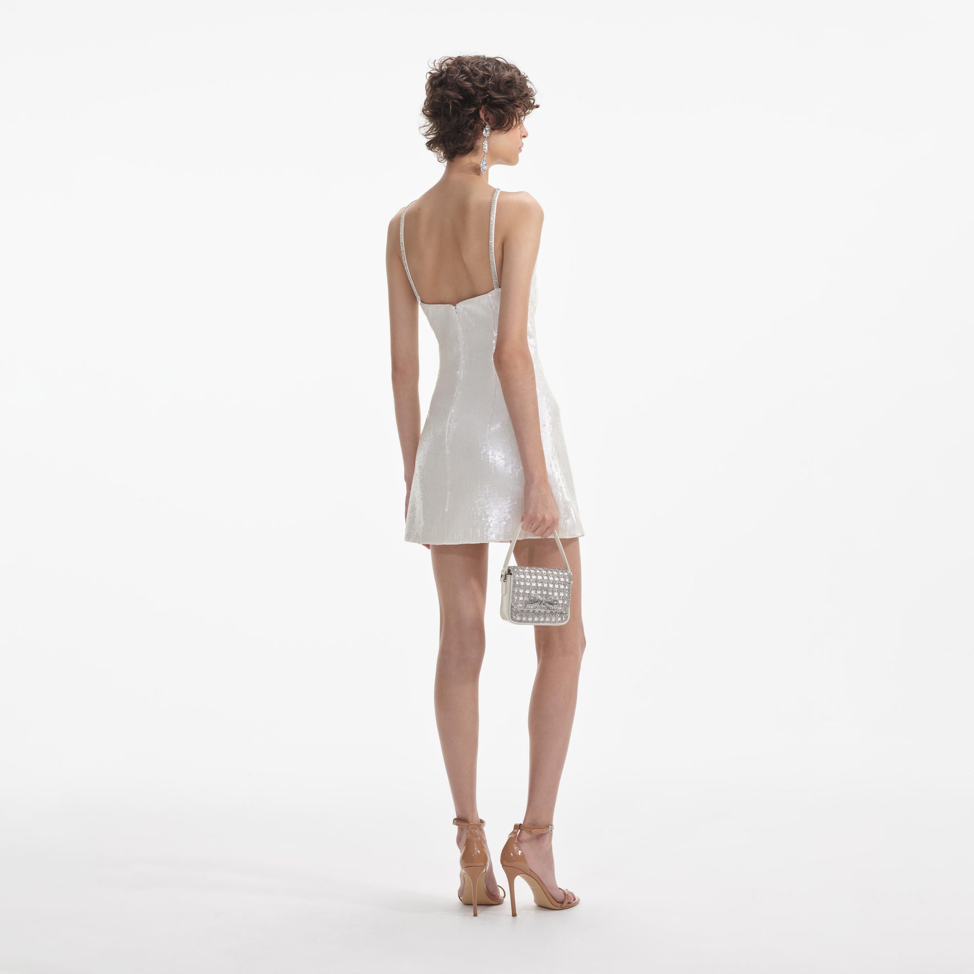 Back view of a woman wearing the White Cream Sequin Halter Mini Dress