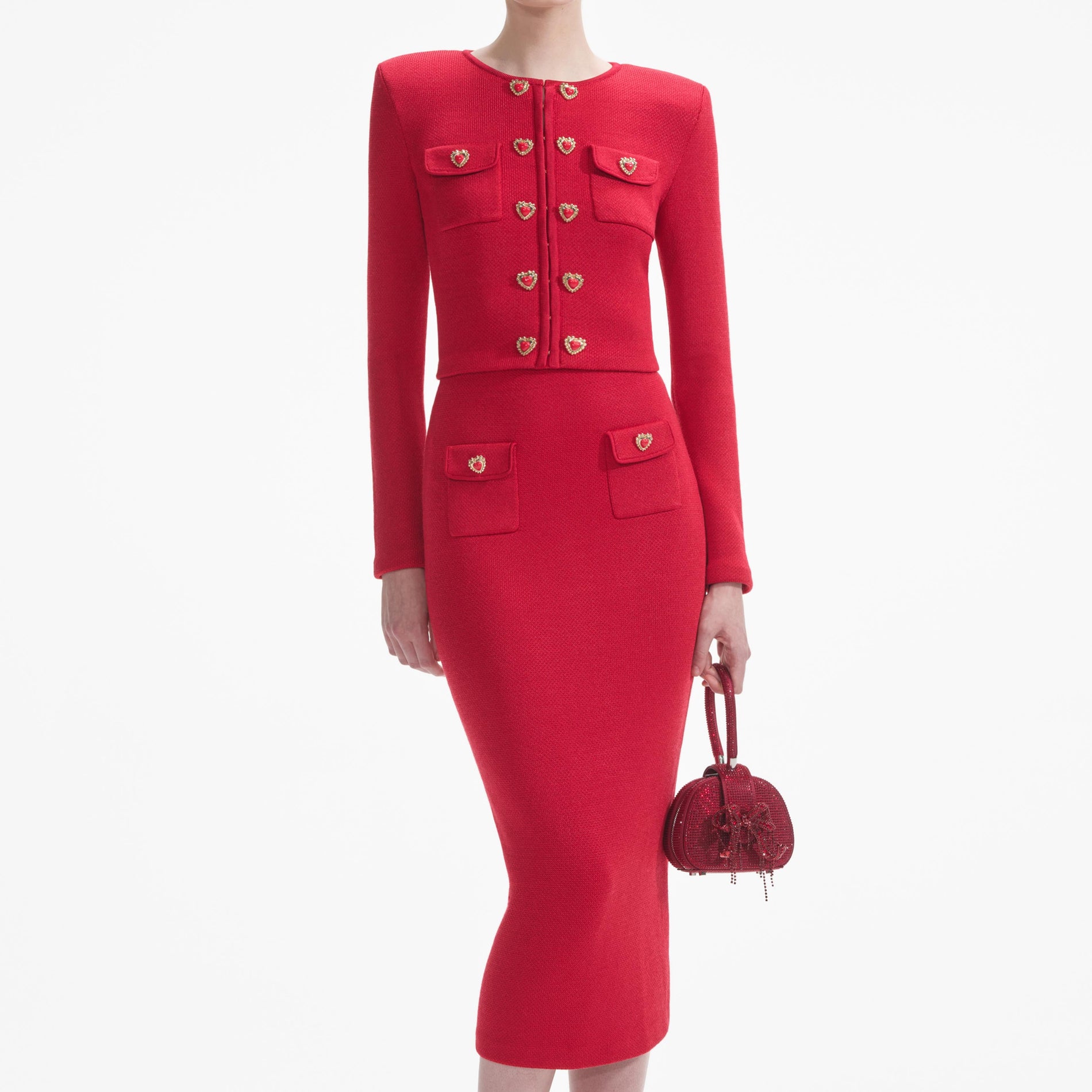 A close up of a woman wearing the Red Knit Heart Buttoned Cardigan