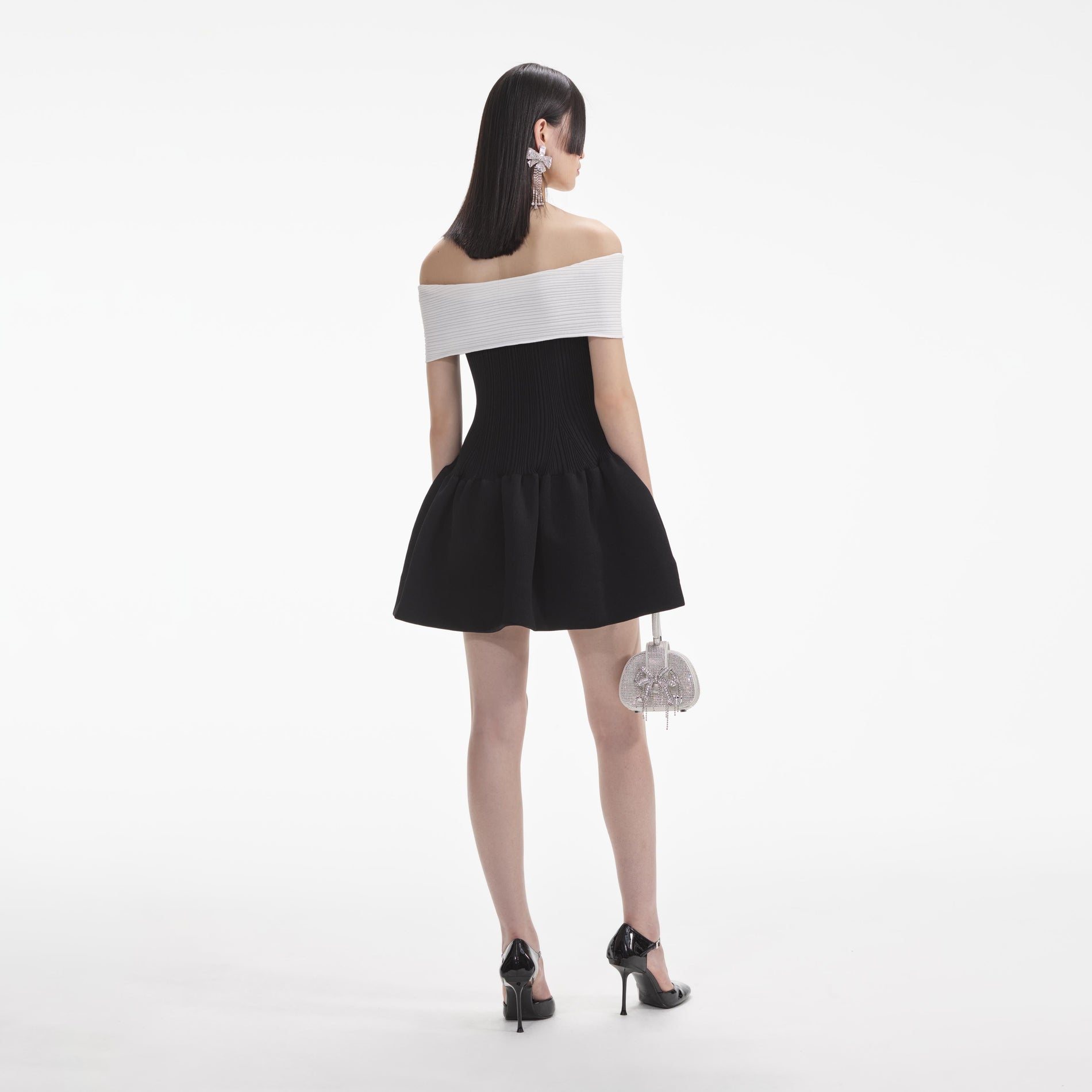 Back view of a woman wearing the White Black Knit Bow Mini Dress