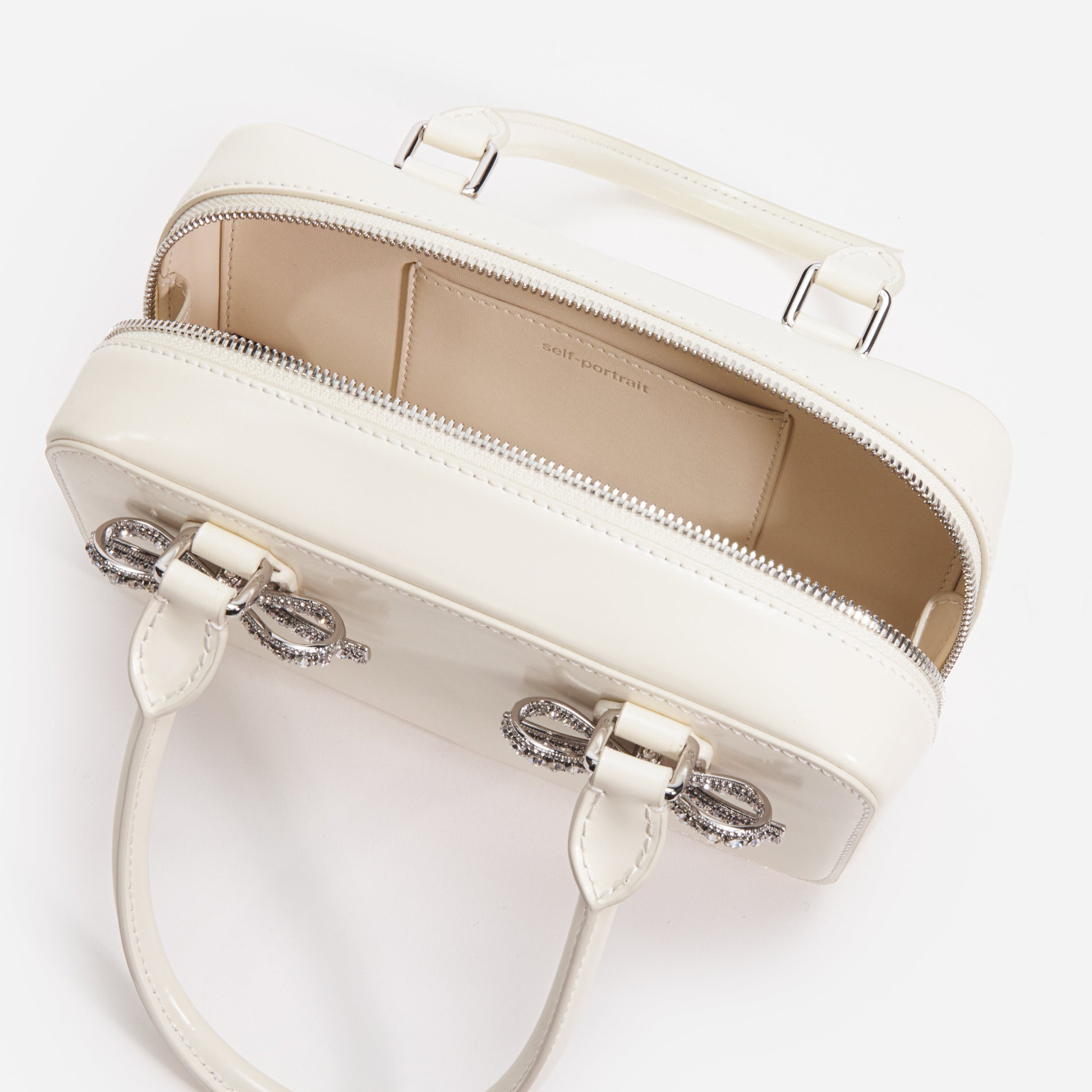 A close up of a woman wearing the Cream Leather Mini Tote Bag