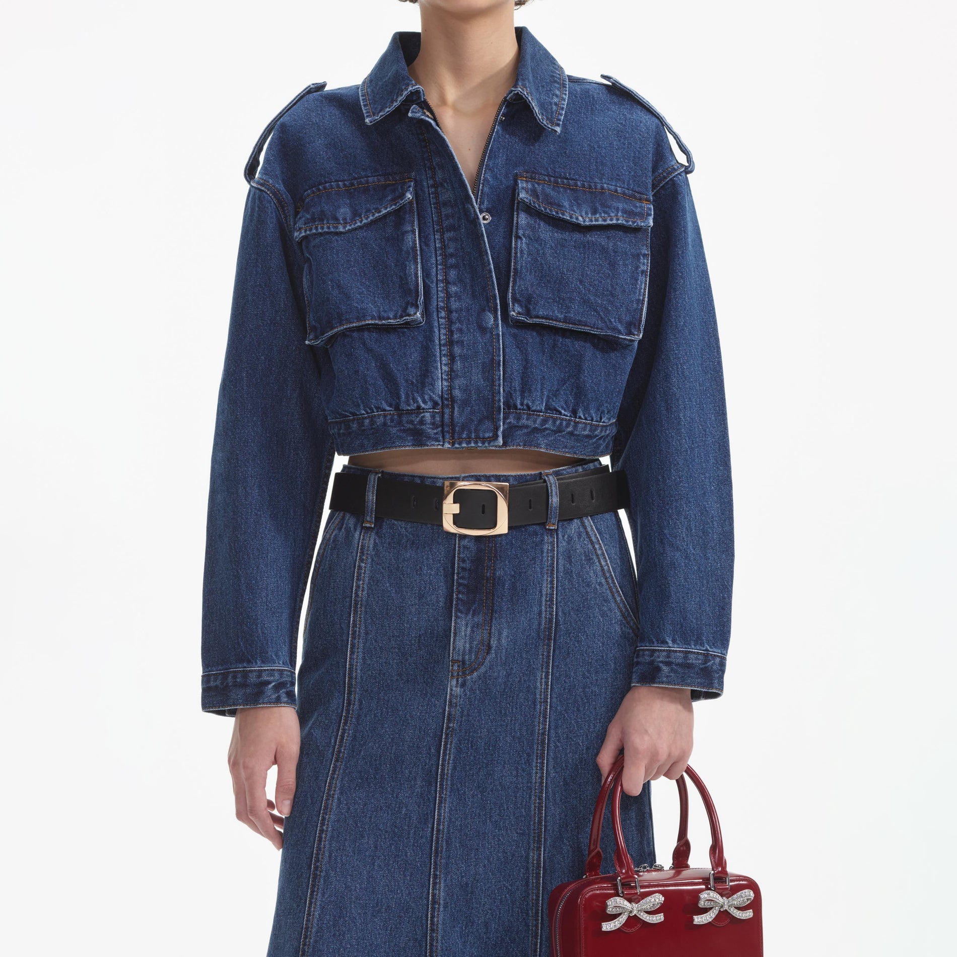 A close up of a woman wearing the Flared Denim Midi Skirt