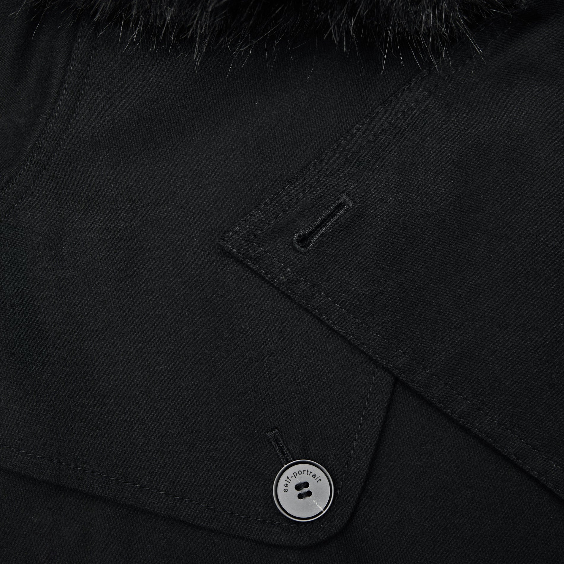 A close up of the fabric for the Black Twill Fur Collar Trench Coat
