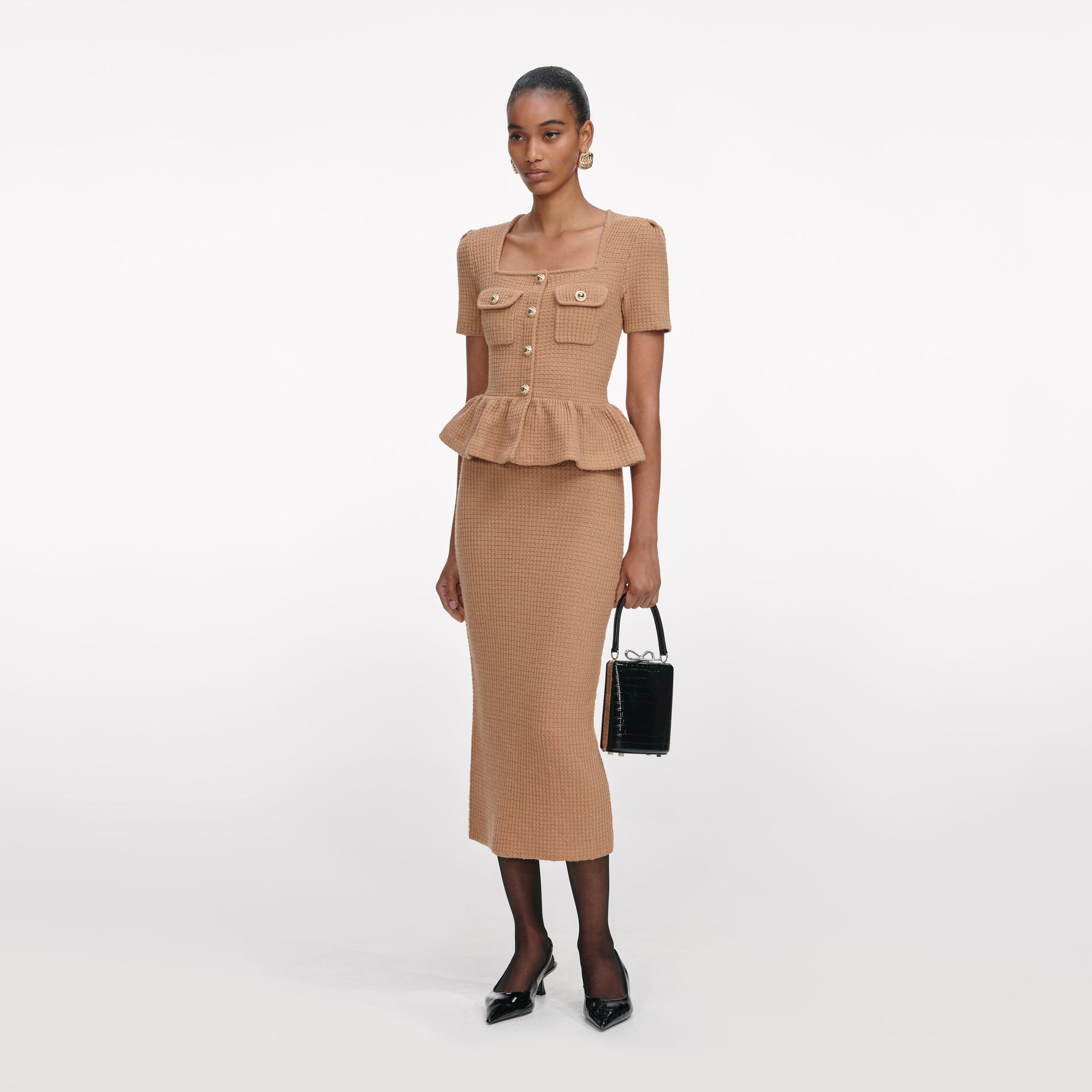 Side view of a woman wearing the Camel Peplum Knit Midi Dress